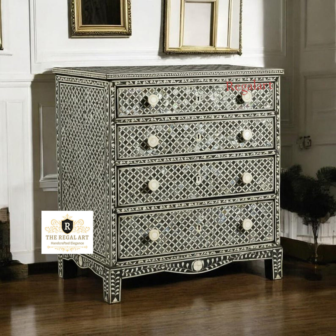 A black square pattern dresser with mother of pearl inlays, featuring three drawers, placed in a room with a decorative mirror above it.