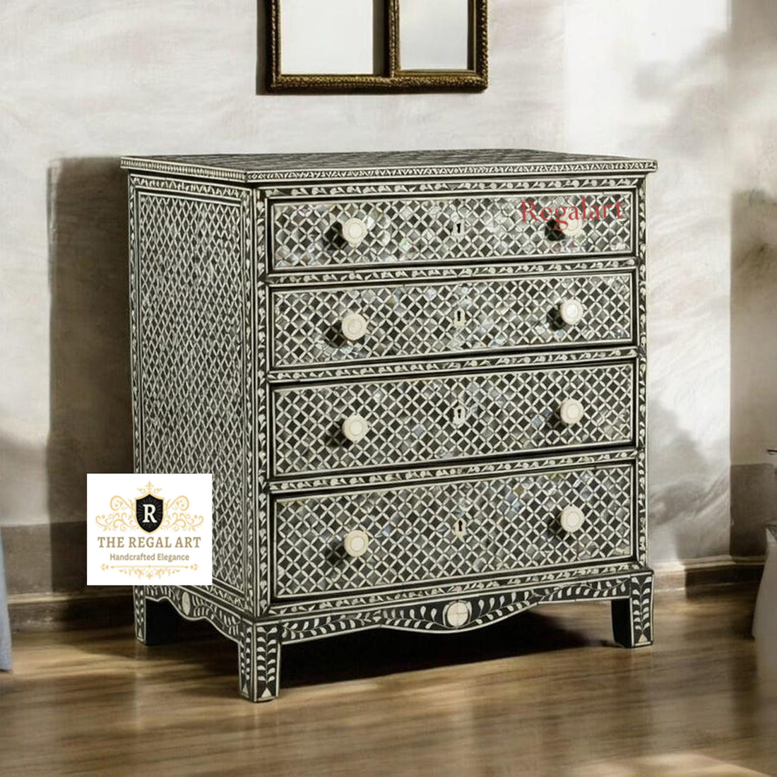 A black square pattern dresser with mother of pearl inlays, featuring three drawers, placed in a room with a decorative mirror above it.