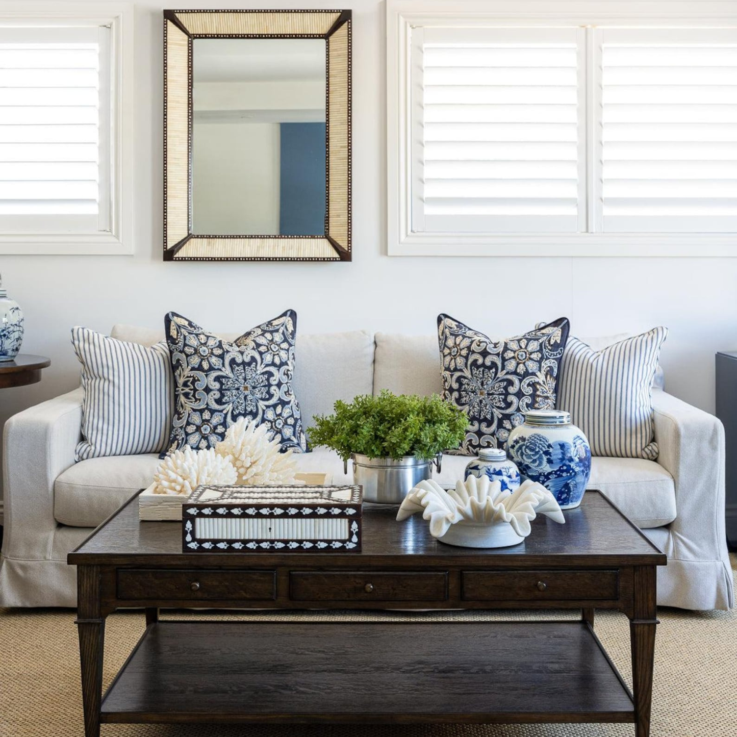 Living room with a white sofa, decorative pillows, and a wooden coffee table.