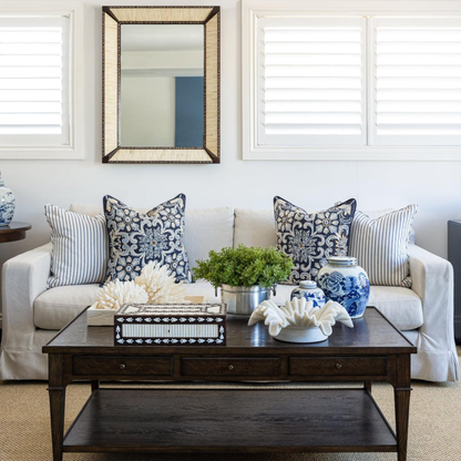 Living room with a white sofa, decorative pillows, and a wooden coffee table.