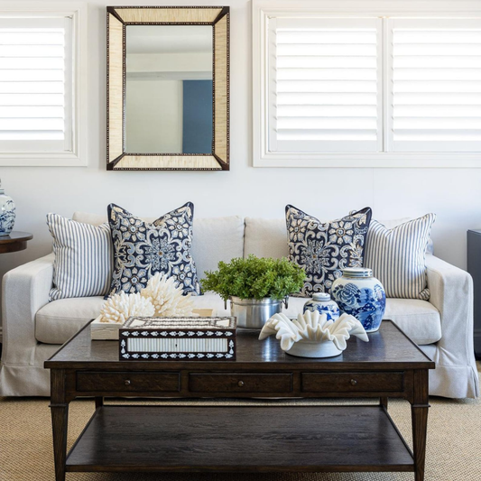Living room with a white sofa, decorative pillows, and a wooden coffee table.
