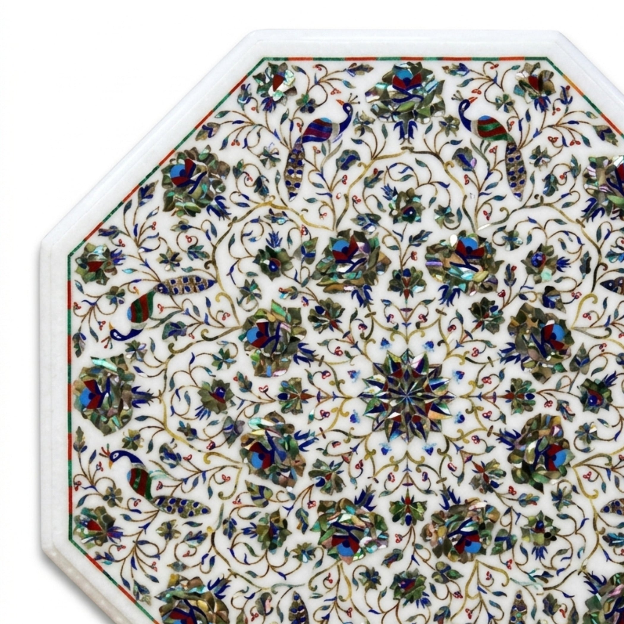 Close-up of handcrafted white marble tabletop showcasing detailed floral and peacock Pietra Dura inlay with colorful semi-precious gemstone craftsmanship.