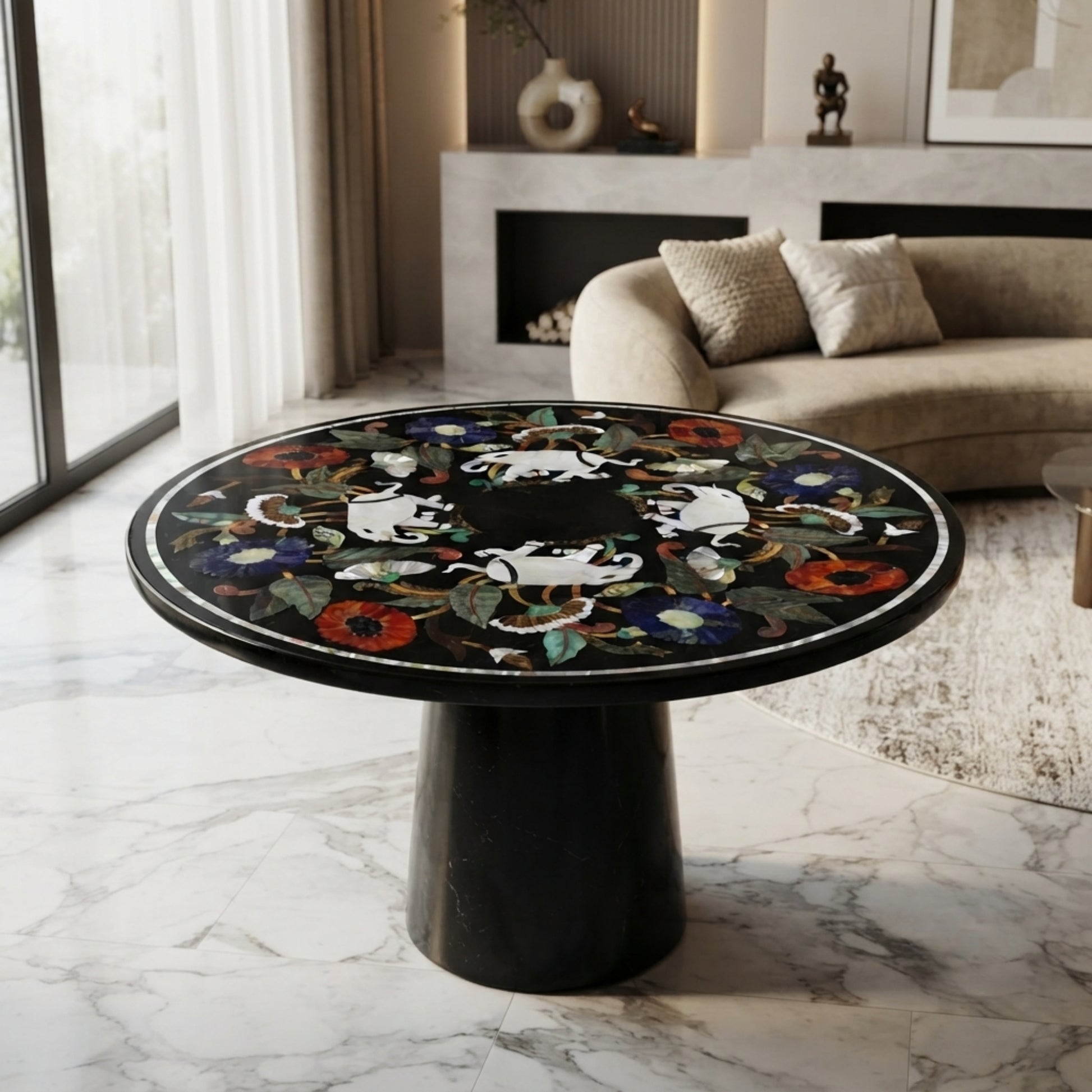 Luxury handcrafted black marble round accent table with elephant and floral gemstone inlay, displayed in a contemporary living room interior.