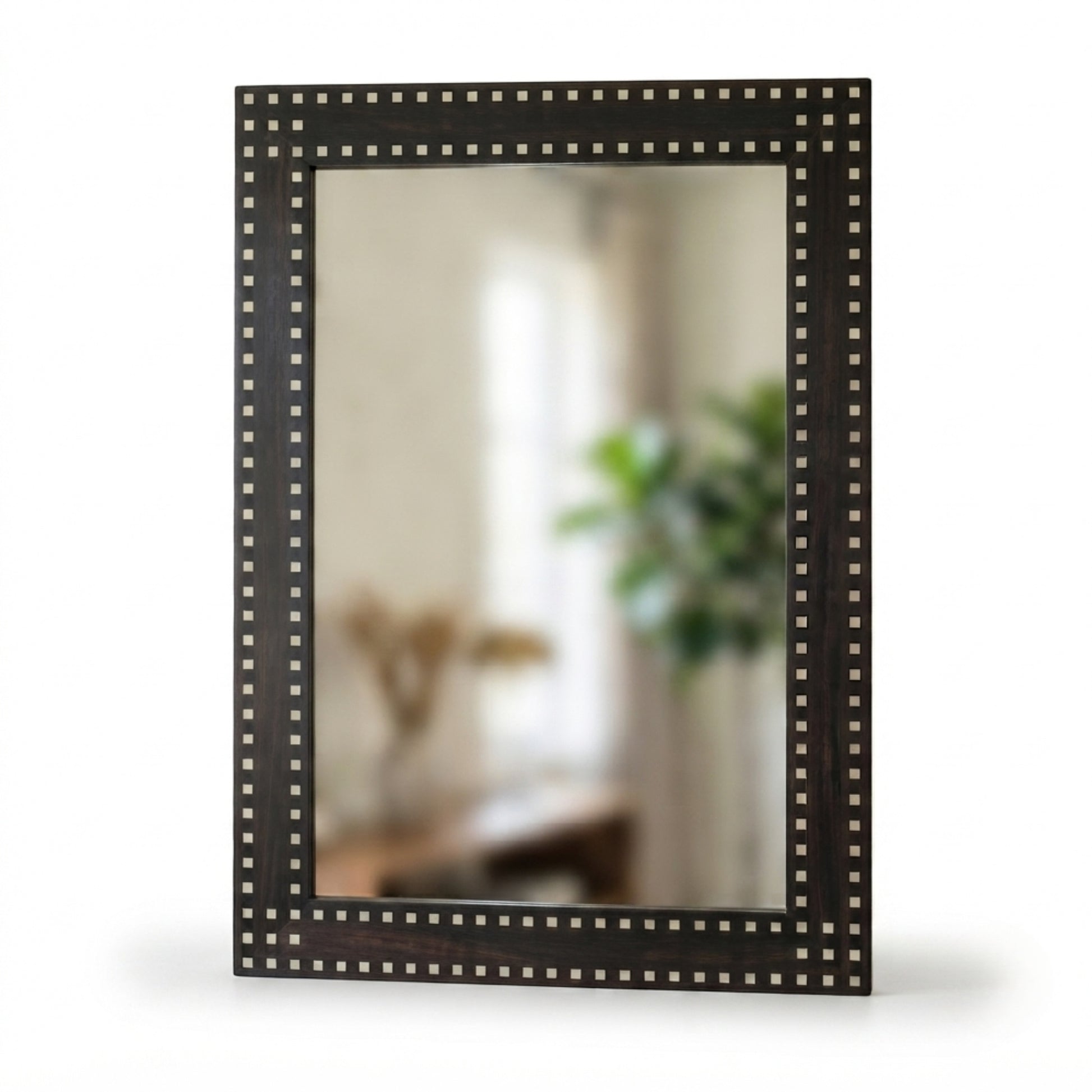 A rectangular wall mirror with a dark brown wooden frame adorned with a border of small metallic studs, shown against a plain white background.
