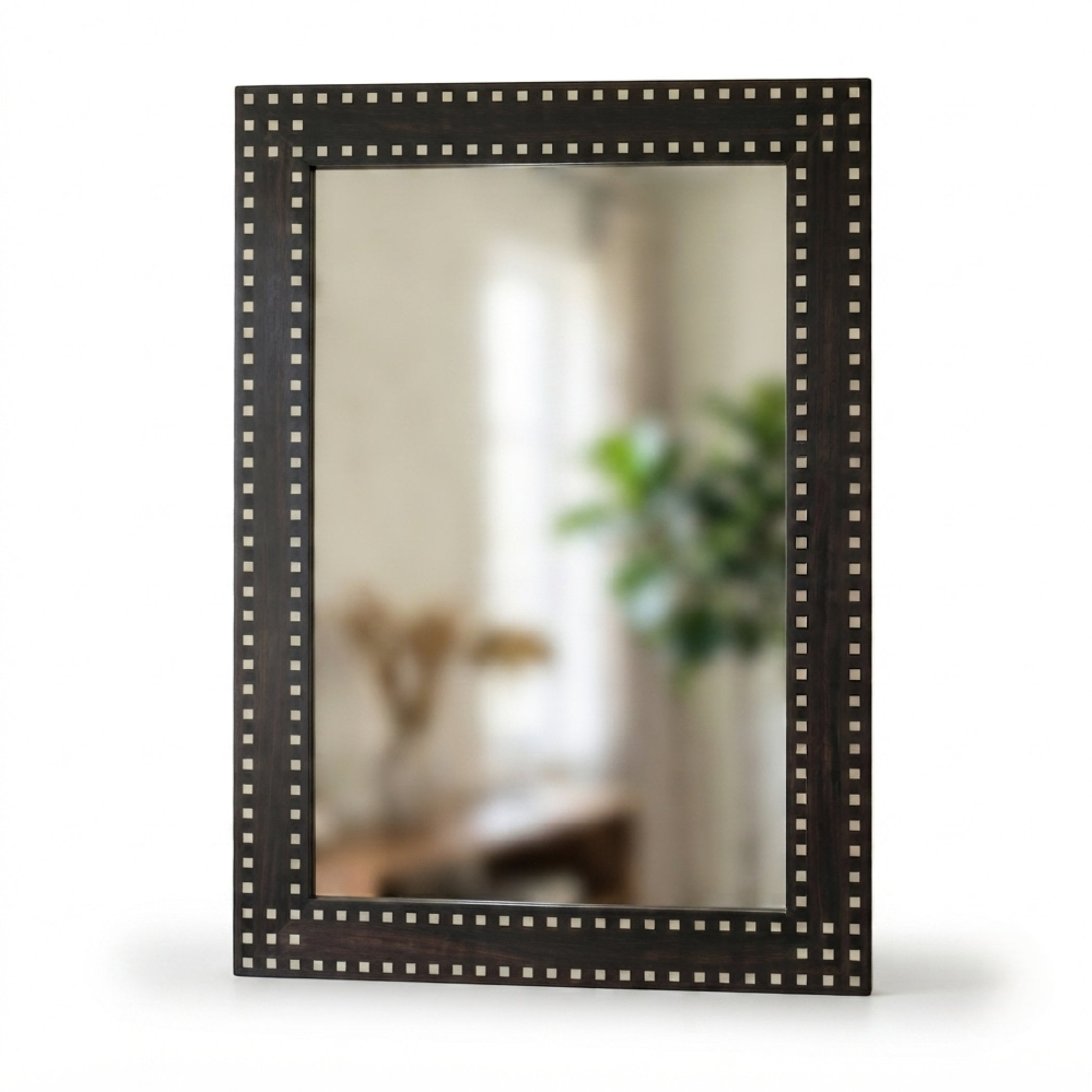A rectangular wall mirror with a dark brown wooden frame adorned with a border of small metallic studs, shown against a plain white background.