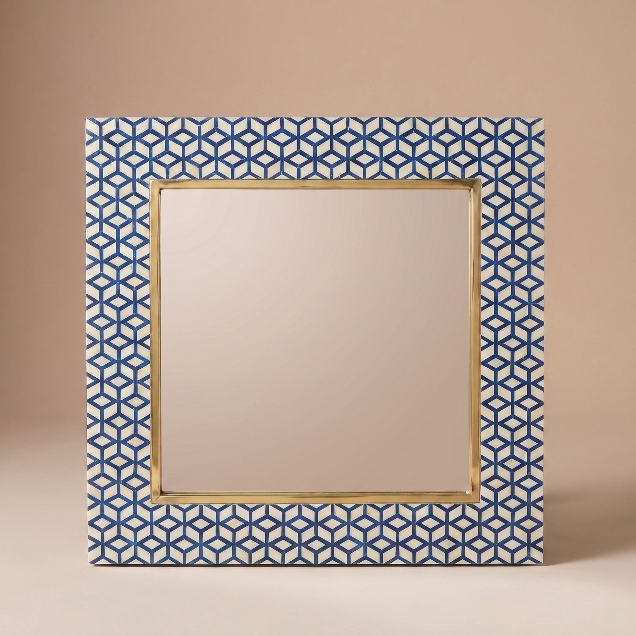A square decorative mirror with a geometric blue and white patterned frame and a gold inner border, shown against a solid beige background.