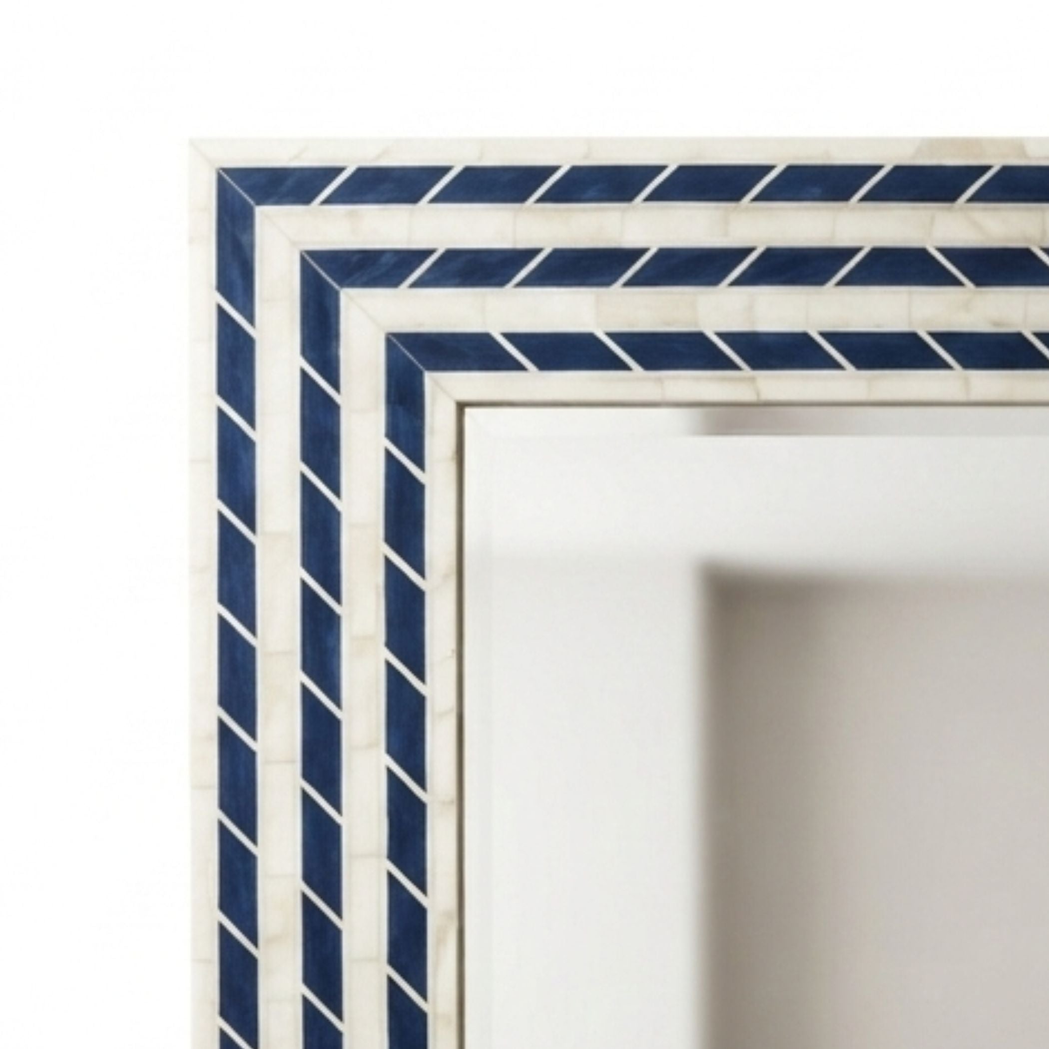 Close-up of a decorative rectangular frame corner with alternating navy blue and white diagonal striped bands on a white background.