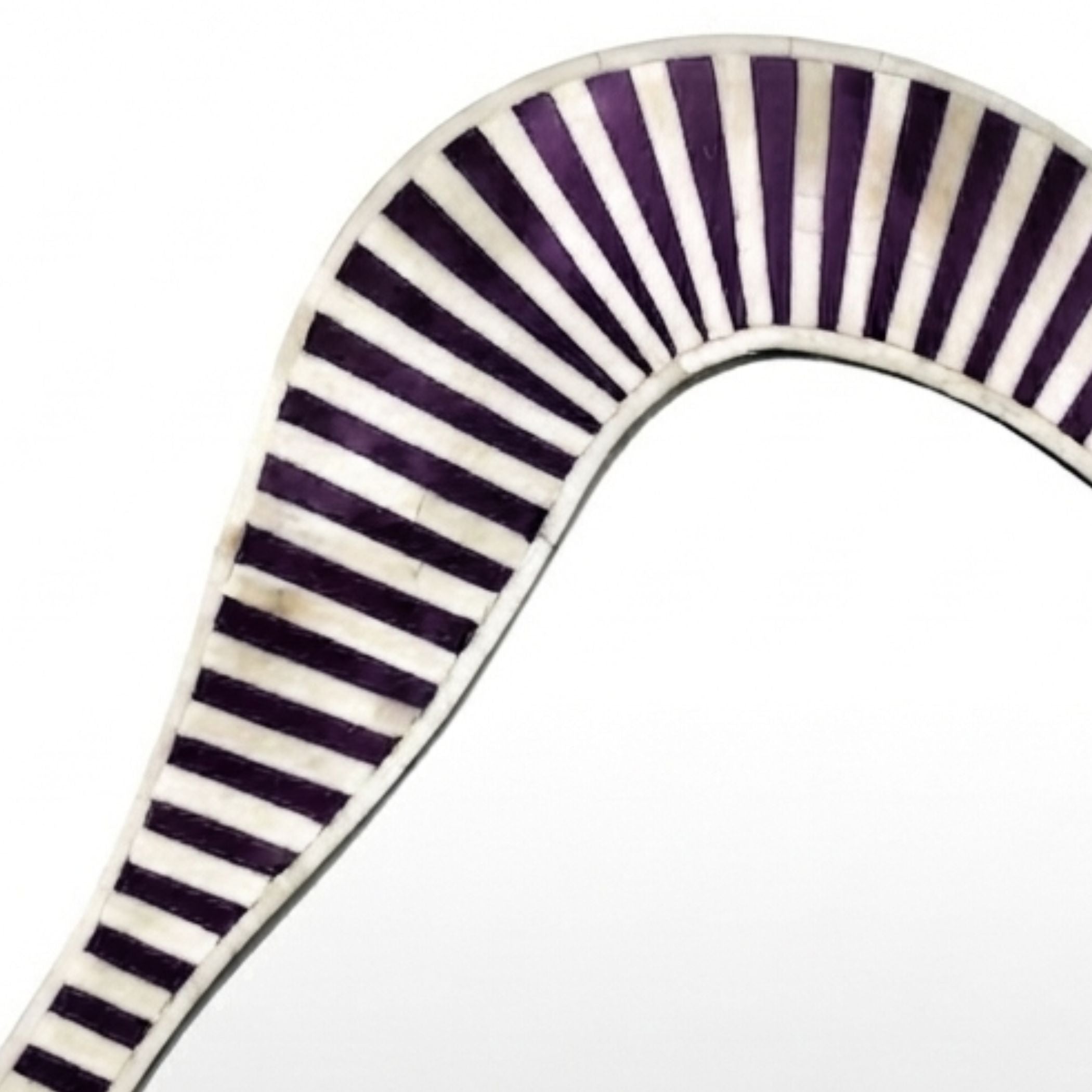 A close-up of a curved mirror frame featuring a striped inlay pattern of dark purple and off-white mother-of-pearl shells, set against a plain white background.