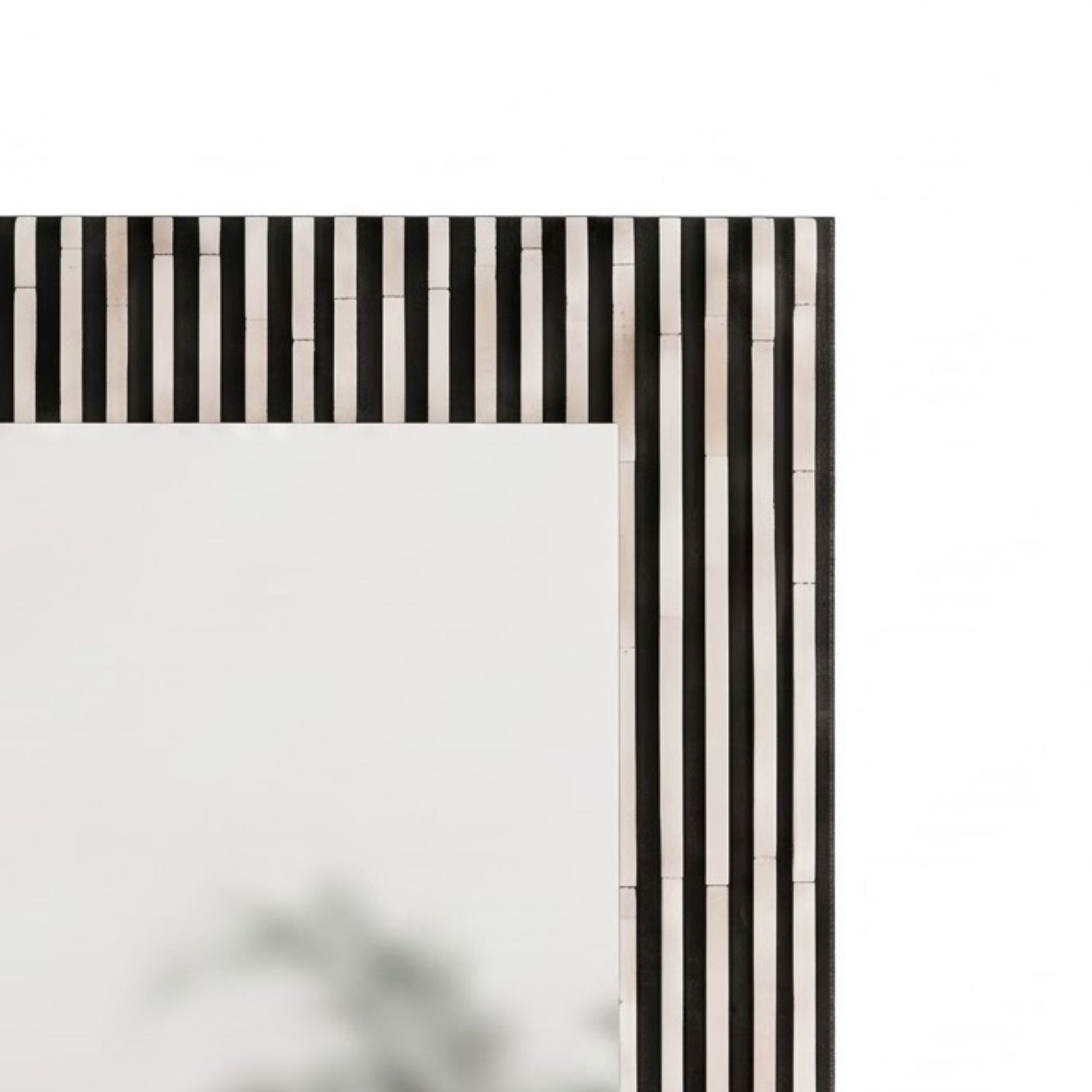 Close-up of a rectangular mirror frame with a black and white vertically striped bone-inlay border, shown against a plain white background.