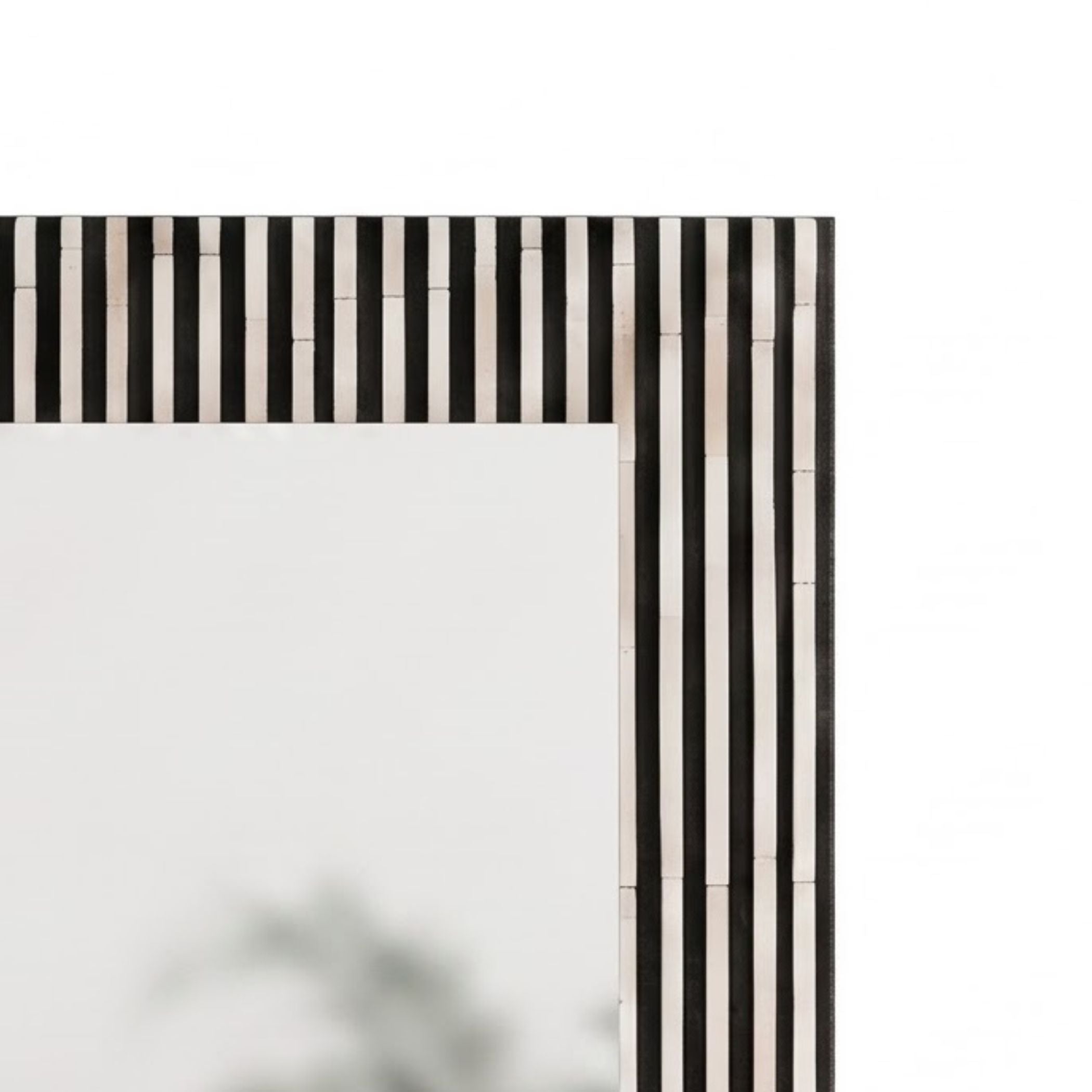 Close-up of a rectangular mirror frame with a black and white vertically striped bone-inlay border, shown against a plain white background.