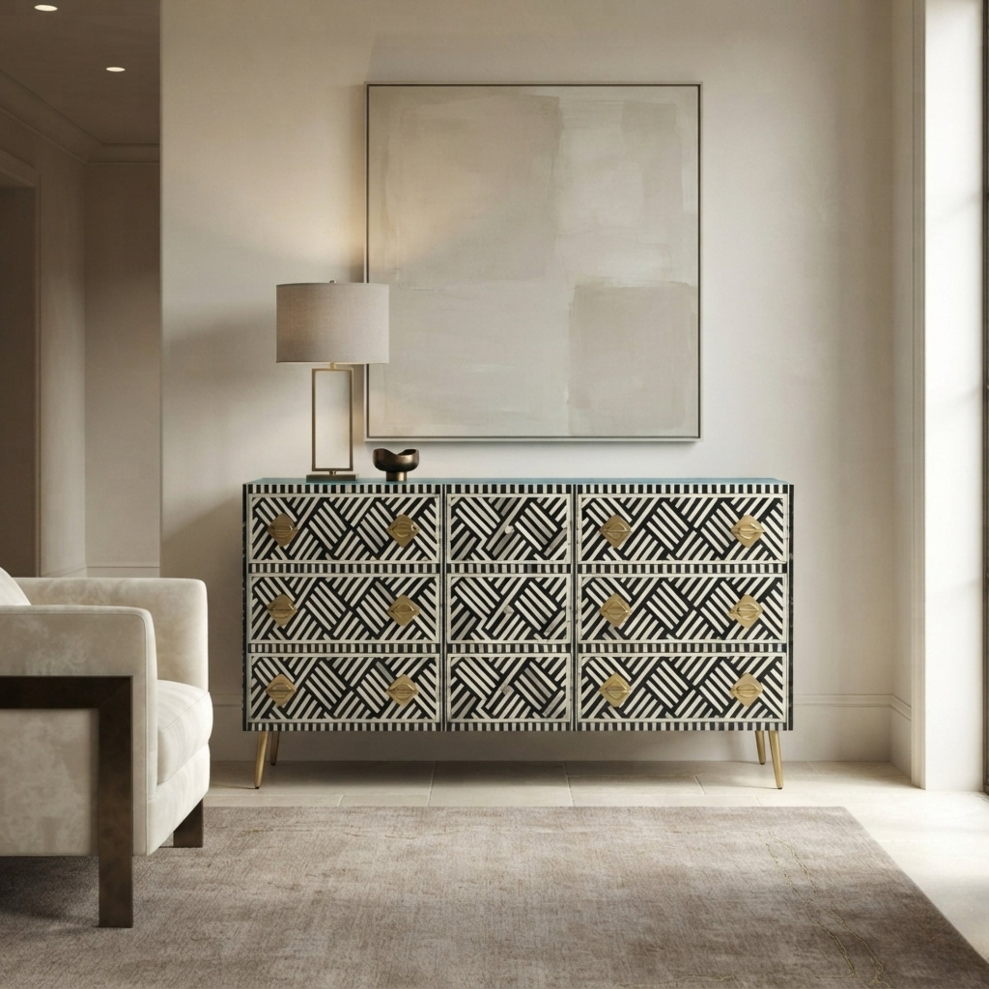 A modern bone-and-wood sideboard cabinet with a black, white, and gold geometric pattern, styled in a minimalist living room setting under a large abstract canvas print.