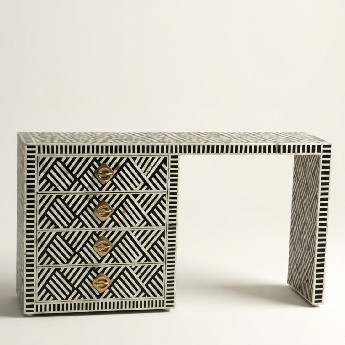 A bone-inset console table with a black and white geometric pattern, four drawers with gold handles, and open shelving, styled in a home interior setting.