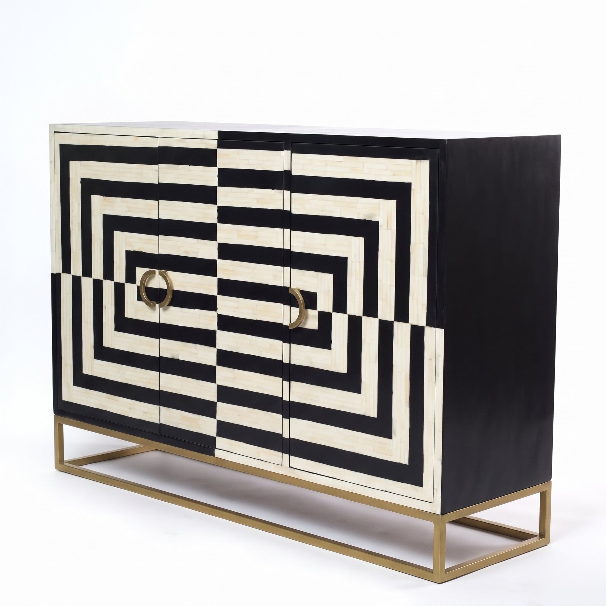 A modern sideboard cabinet featuring a bold black and off-white geometric pattern on the front doors, with two round gold ring pulls and a slim gold metal base frame, set against a plain white background.