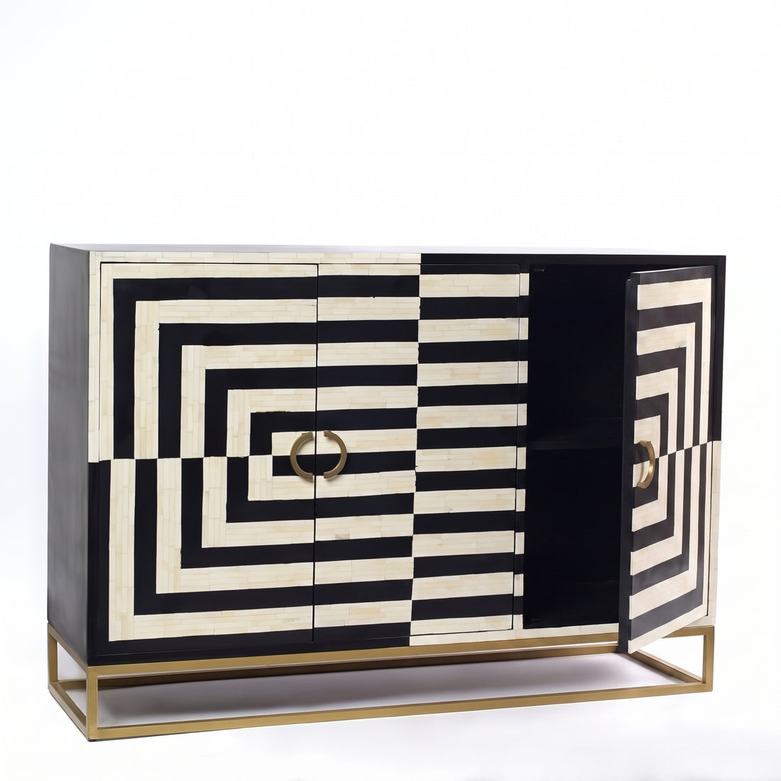 A black and white geometric patterned sideboard cabinet with gold metal legs and handles, styled in a modern room next to a cream armchair, a gold table lamp, and a round mirror against a dark gray wall.