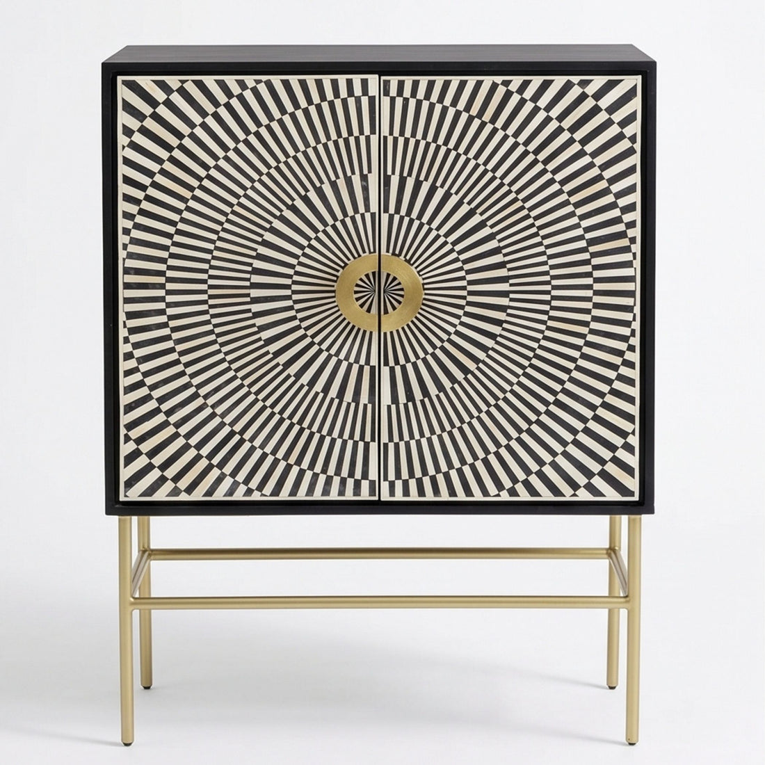 A modern sideboard cabinet with a black and white geometric sunburst pattern on the doors and a gold metal frame and legs, styled in a warm beige room next to a textured armchair.