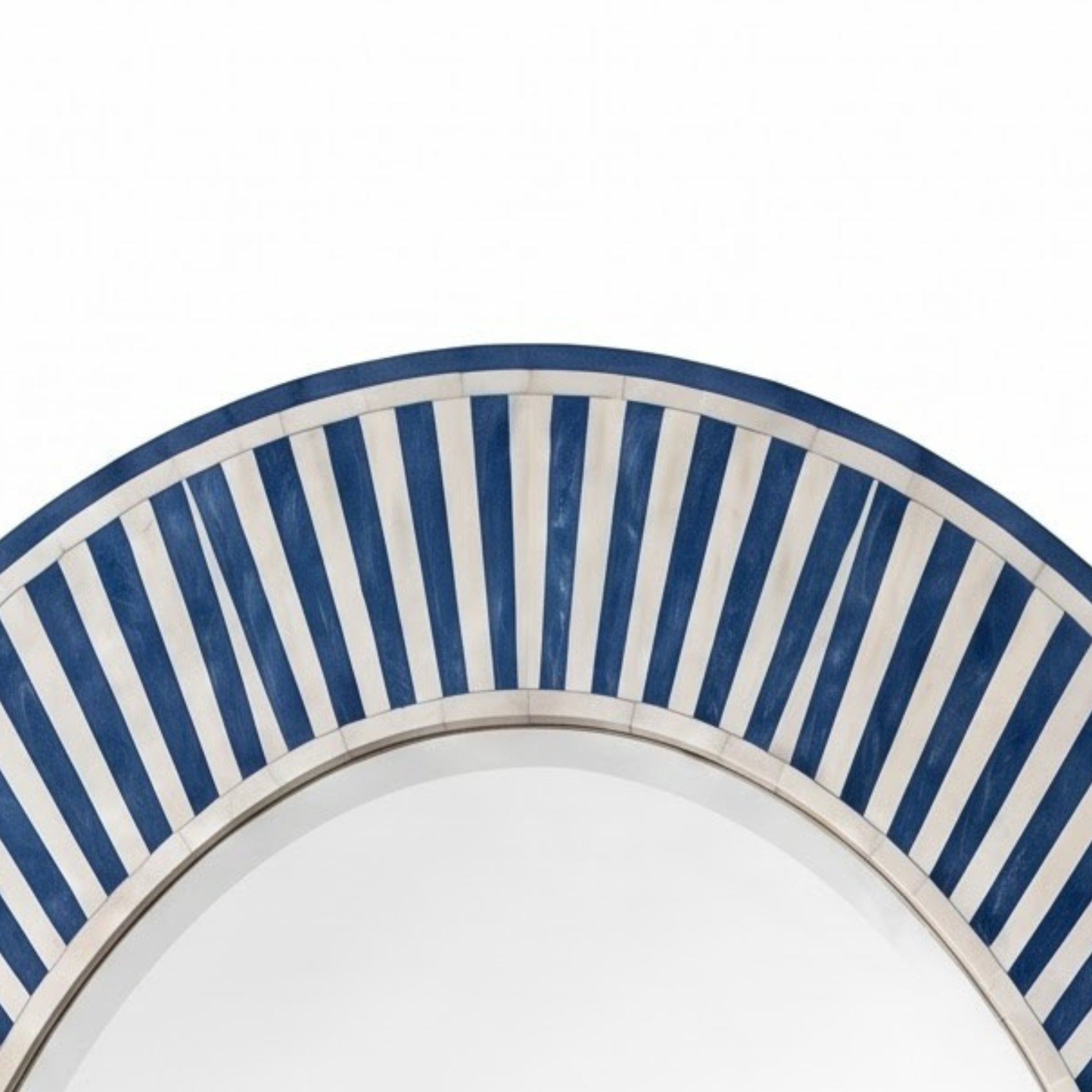 Close-up of an arched decorative mirror frame featuring alternating navy blue and white vertical stripes, with a thin metallic trim visible along the lower edge.