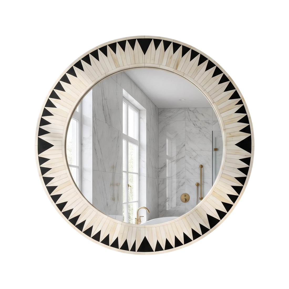 A large round wall mirror with a black and white geometric sunburst frame hangs above a white marble console table in a styled interior room.