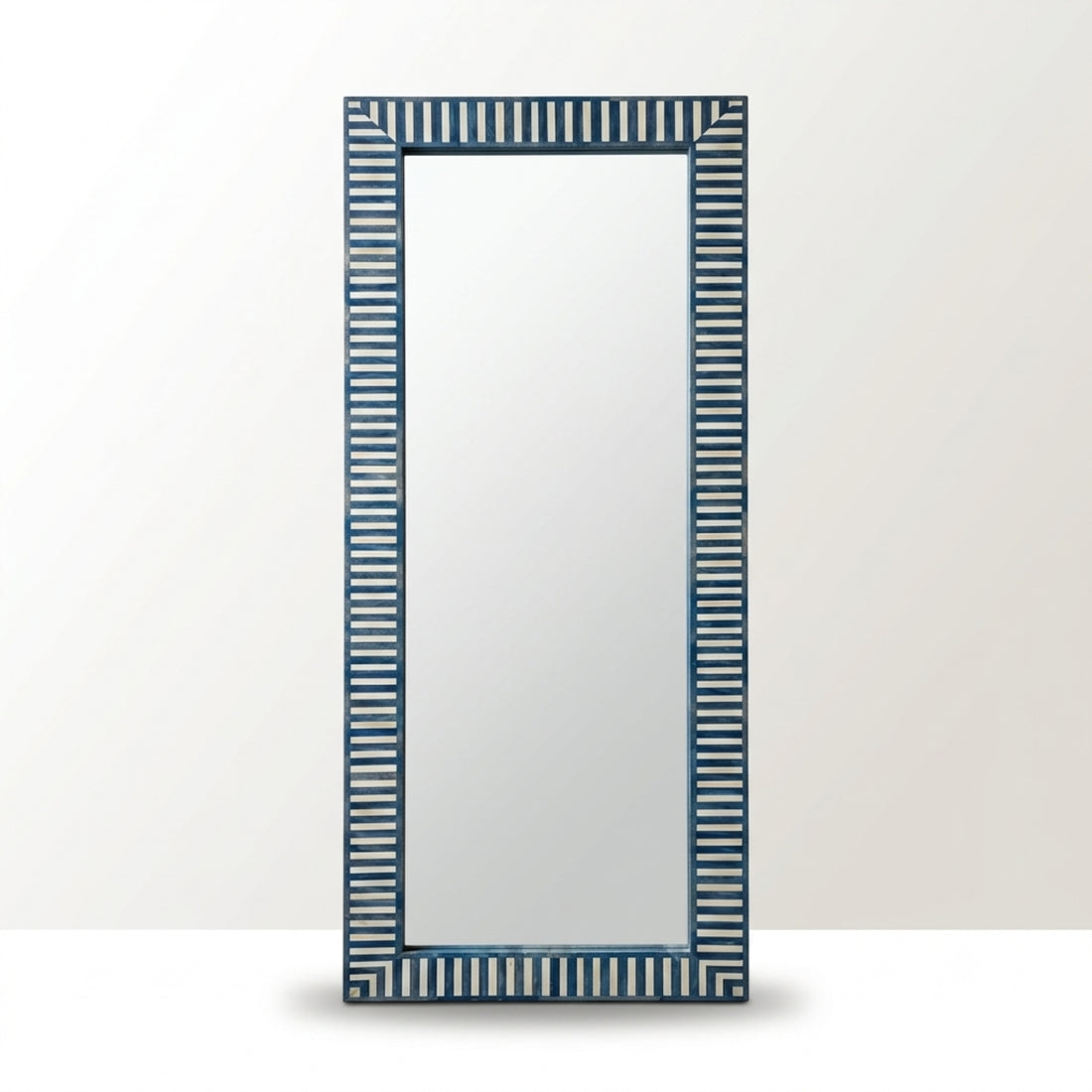 A tall rectangular wall mirror with a dark blue and white vertically striped frame, shown against a light gray background.