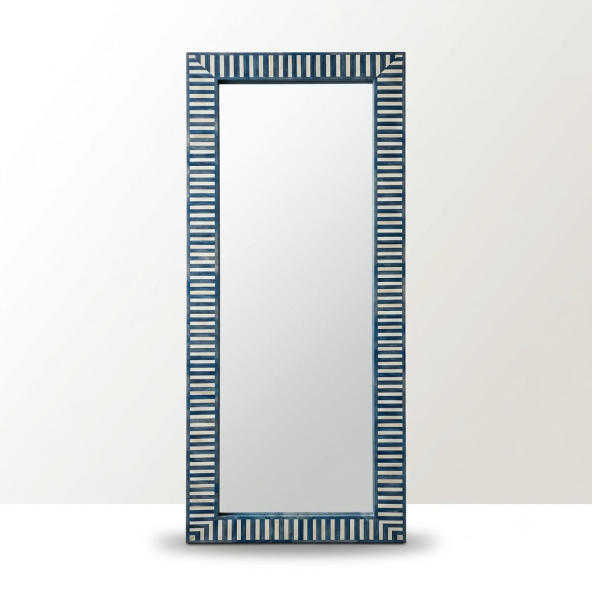 A tall rectangular wall mirror with a dark blue and white vertically striped frame, shown against a light gray background.