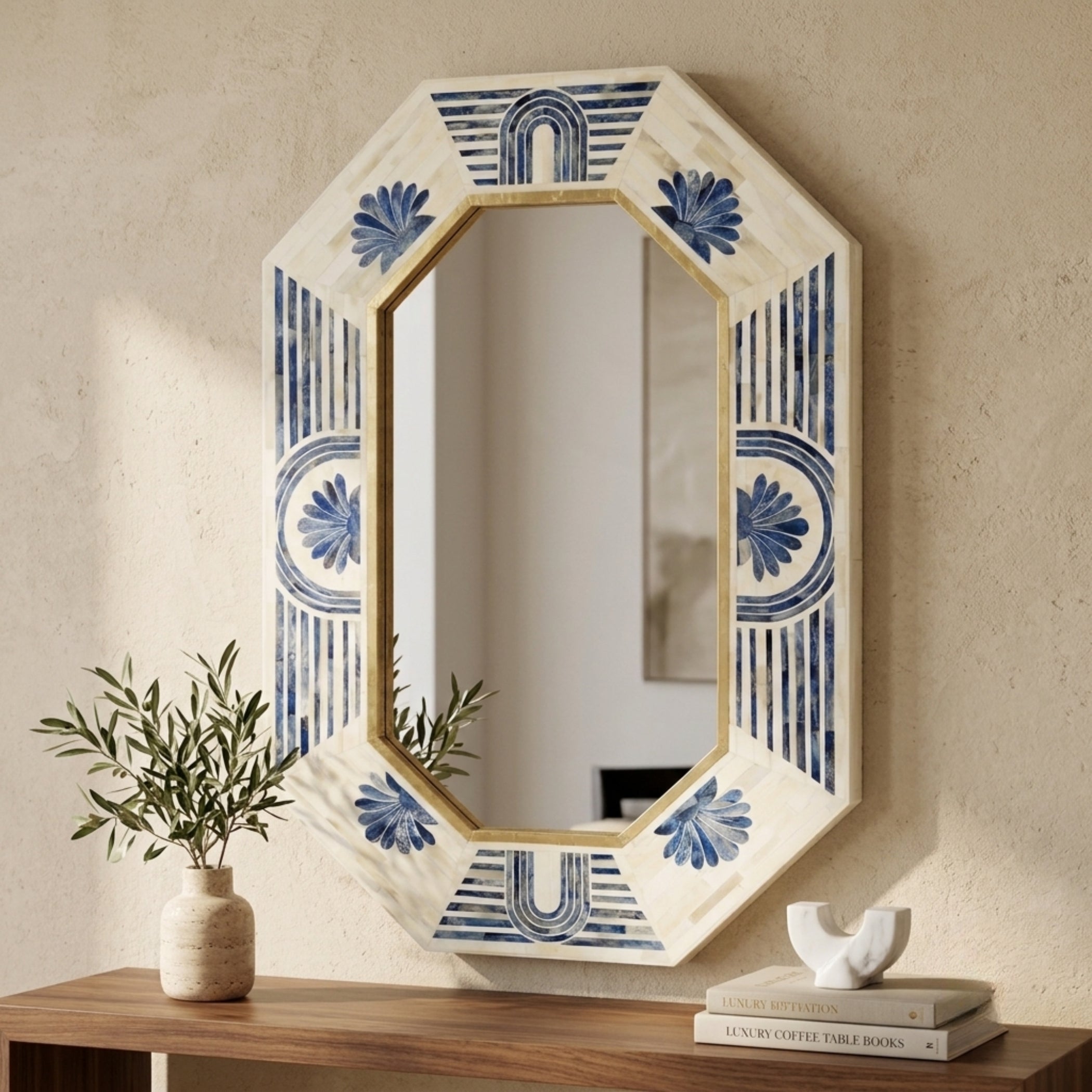 An octagonal decorative wall mirror with a cream-colored frame featuring blue floral and striped patterns, styled on a wooden console table against a textured beige wall.