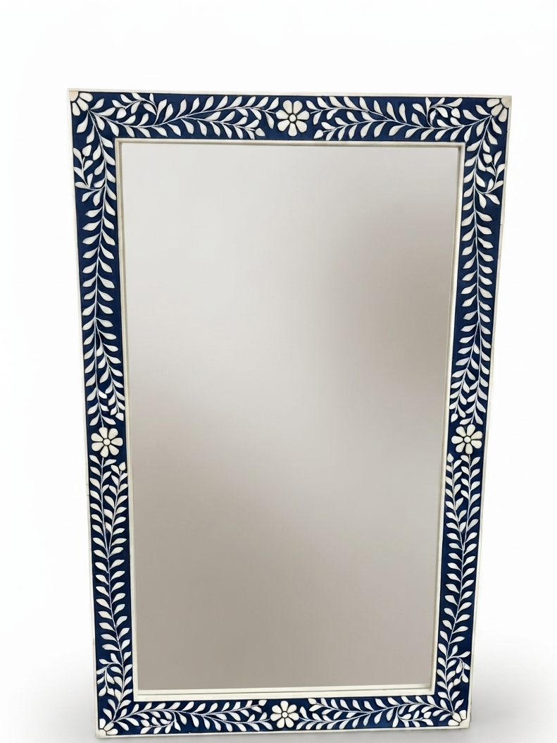 A rectangular wall mirror with a decorative border featuring white leaf and floral motifs on a dark navy blue background, shown against a clean white studio backdrop.