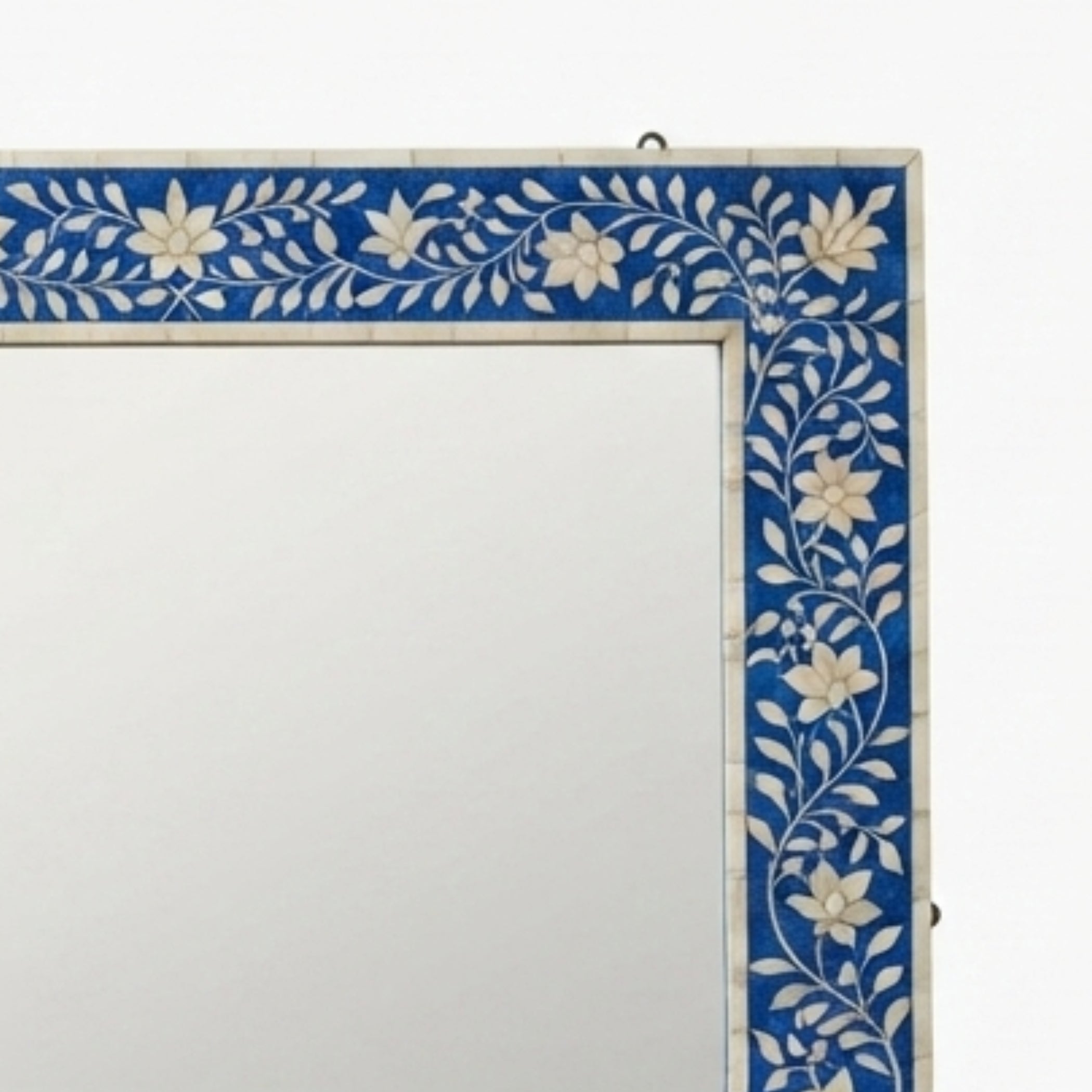 A square wall mirror with a decorative border featuring blue and white floral inlay, shown against a plain white background.