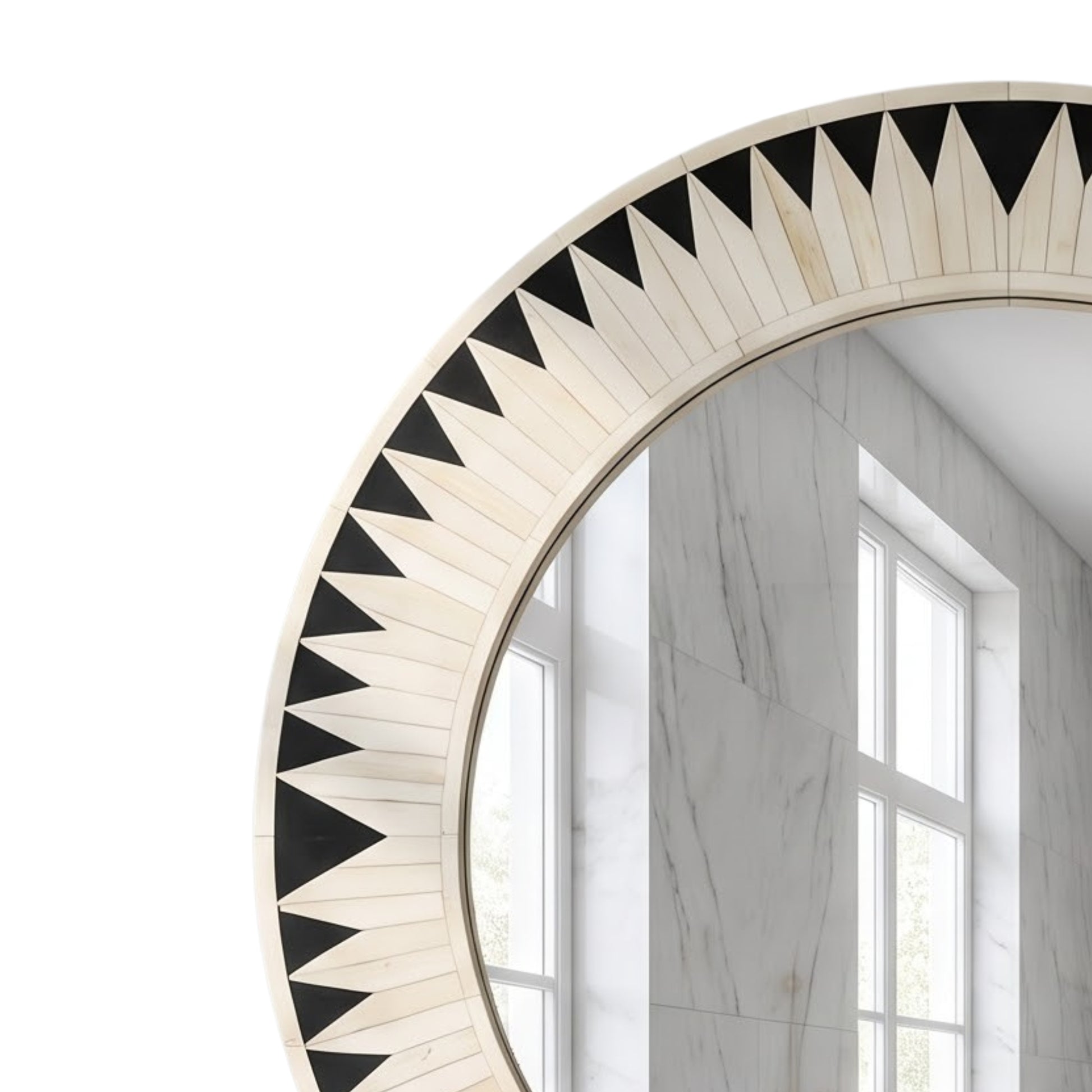 A close-up of a round wall mirror with a decorative border made of alternating black and off-white triangular inlays, shown against a white background with a reflection of a marble-walled room.