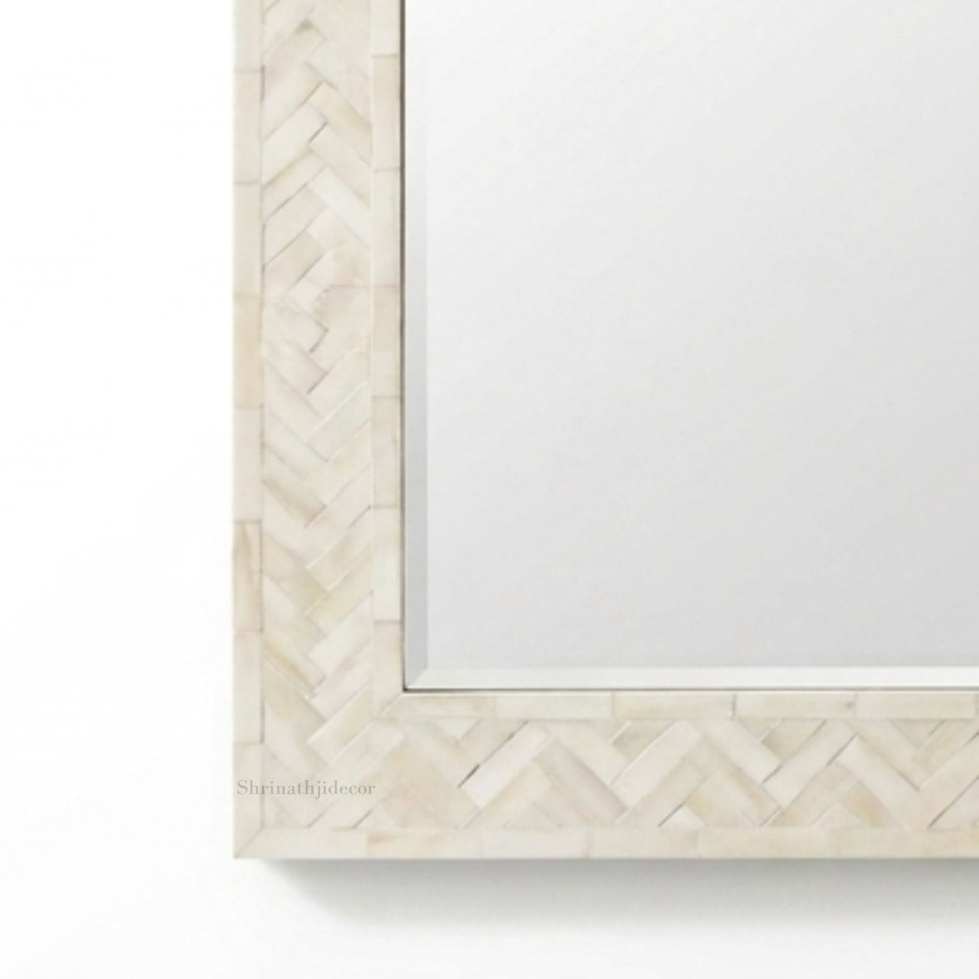 Close-up of a decorative rectangular mirror frame with a light beige herringbone inlay border on a white background.