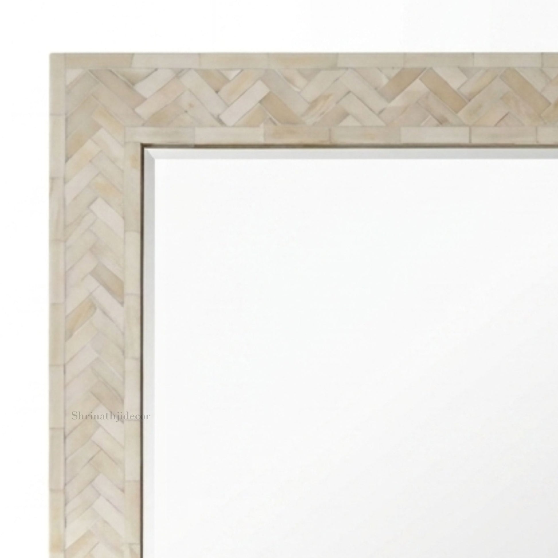 Close-up of a rectangular mirror with a light beige herringbone-patterned frame on a white background.