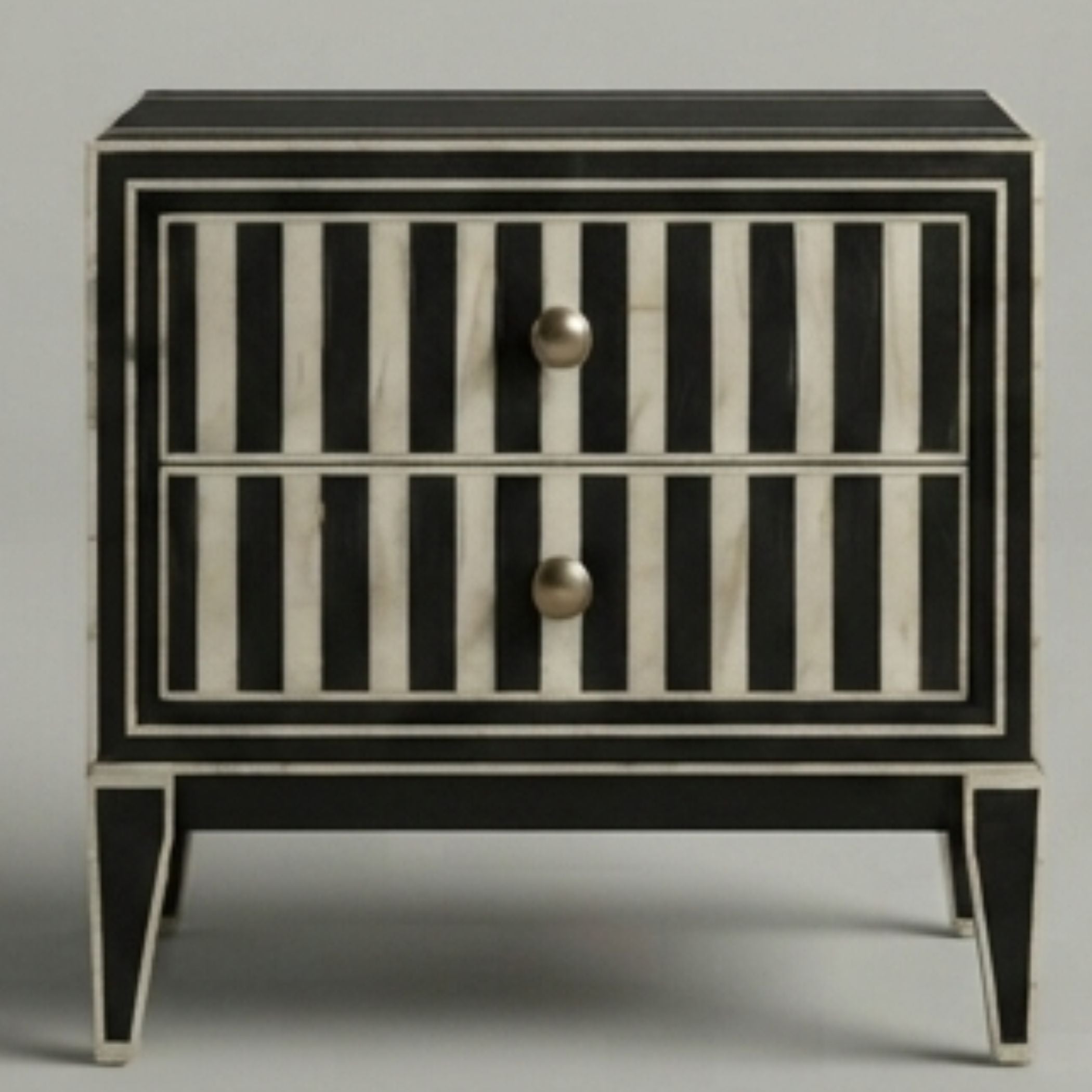 A two-drawer nightstand featuring a black and white striped bone-inlay design with round metallic knobs, set against a neutral gray background.