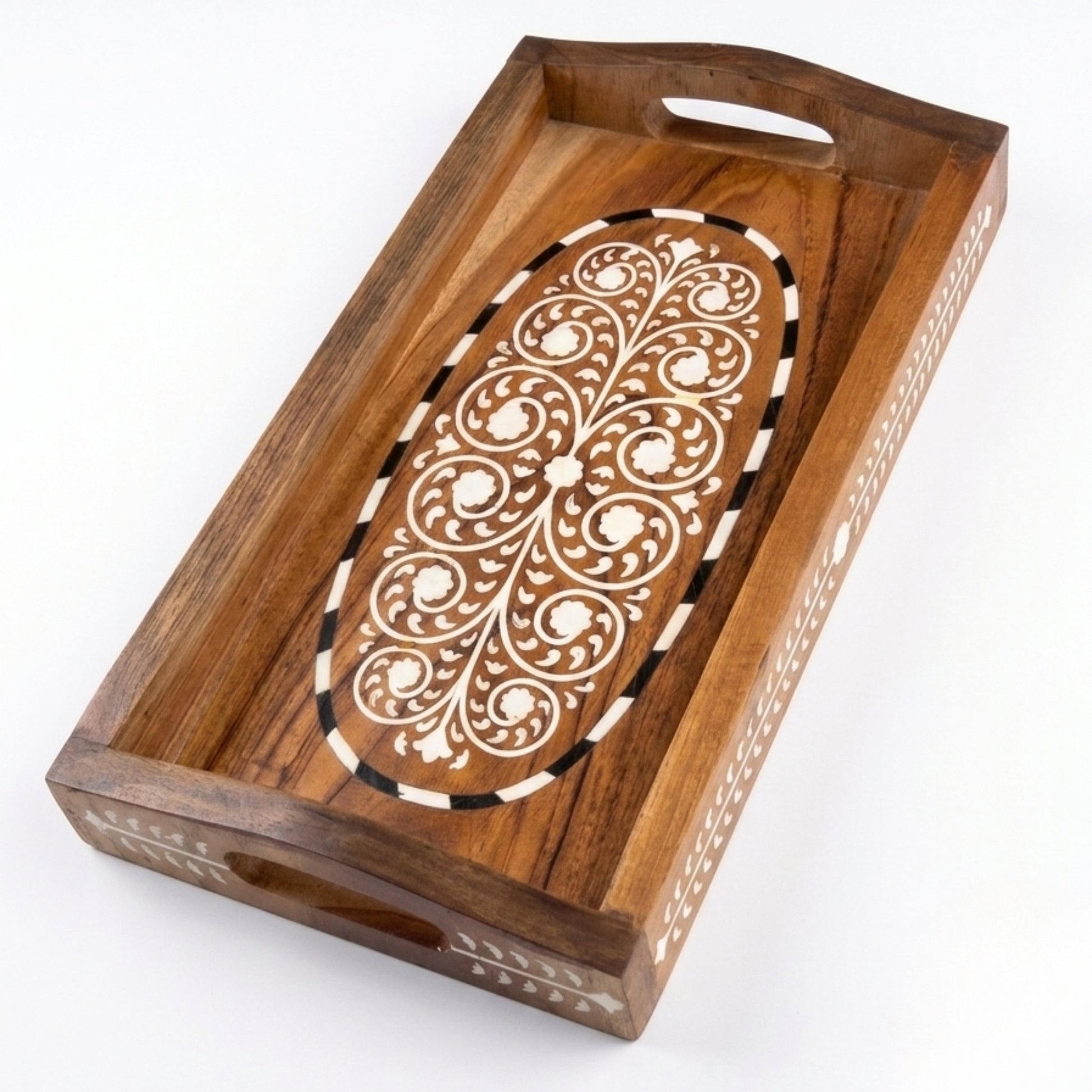 A rectangular wooden serving tray with integrated handles, featuring an ornate oval inlay design in the center with cream floral patterns and black-and-white geometric borders, set against a plain white background.