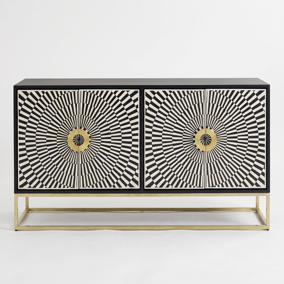 A modern black and white striped sideboard cabinet with gold accents, styled in a room setting with a round gold-framed mirror, a gold floor lamp, a white vase with flowers, and a potted fiddle-leaf fig plant against a dark gray wall.