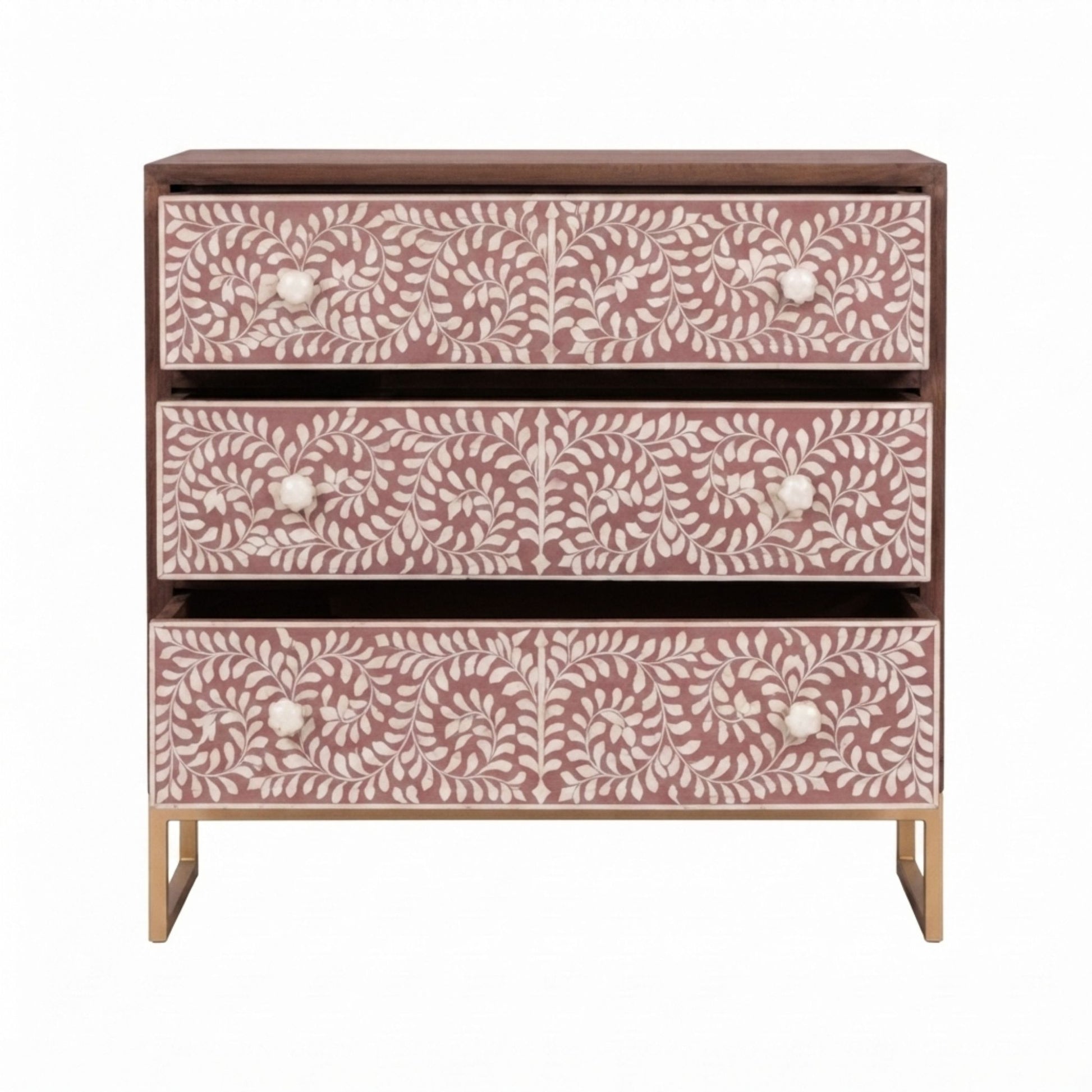 A three-drawer chest of drawers with dusty rose pink and white bone-inlay floral patterns, a dark brown wood top and frame, and gold metal legs, shown against a plain white background.