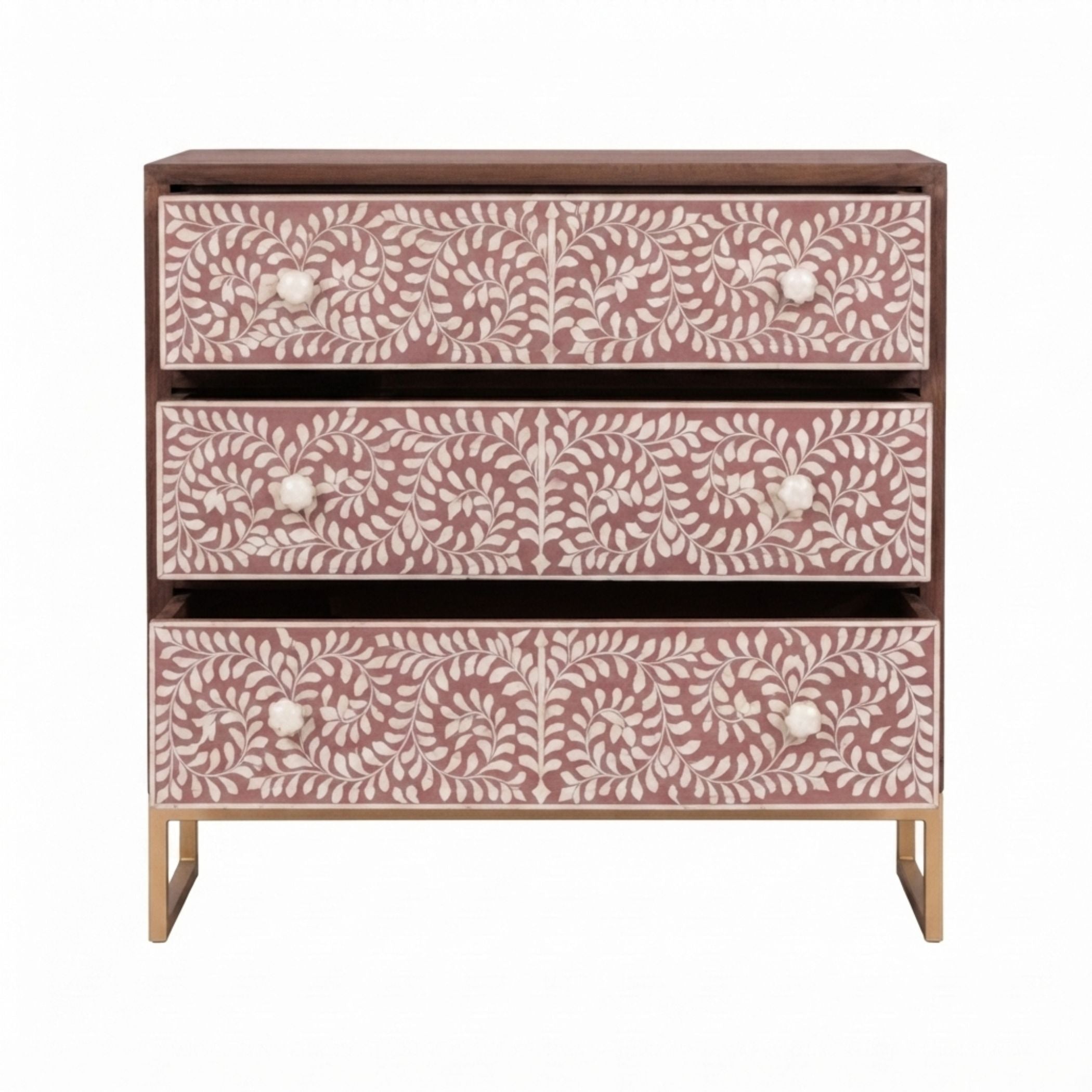 A three-drawer chest of drawers with dusty rose pink and white bone-inlay floral patterns, a dark brown wood top and frame, and gold metal legs, shown against a plain white background.