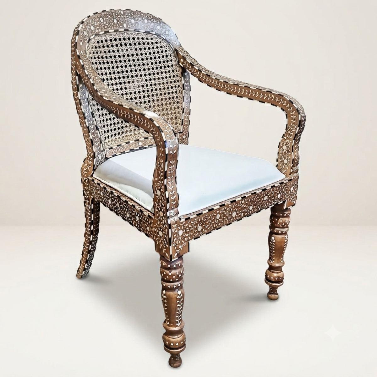 An ornate vintage-style armchair featuring a carved brown wooden frame, a woven cane backrest, and a light blue upholstered seat cushion, set against a plain beige background.