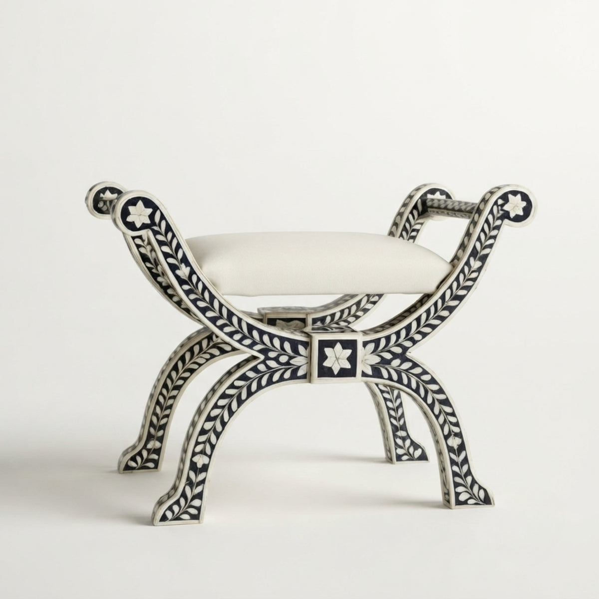 An ornate bench with a white upholstered seat cushion and a silver-toned frame decorated with intricate black inlay patterns, photographed against a clean white background.