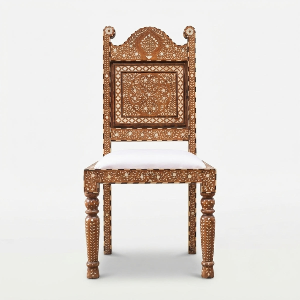 An ornate carved wooden chair with intricate mother-of-pearl inlay work on the backrest and legs, featuring a white upholstered seat cushion, shown against a plain light gray background.