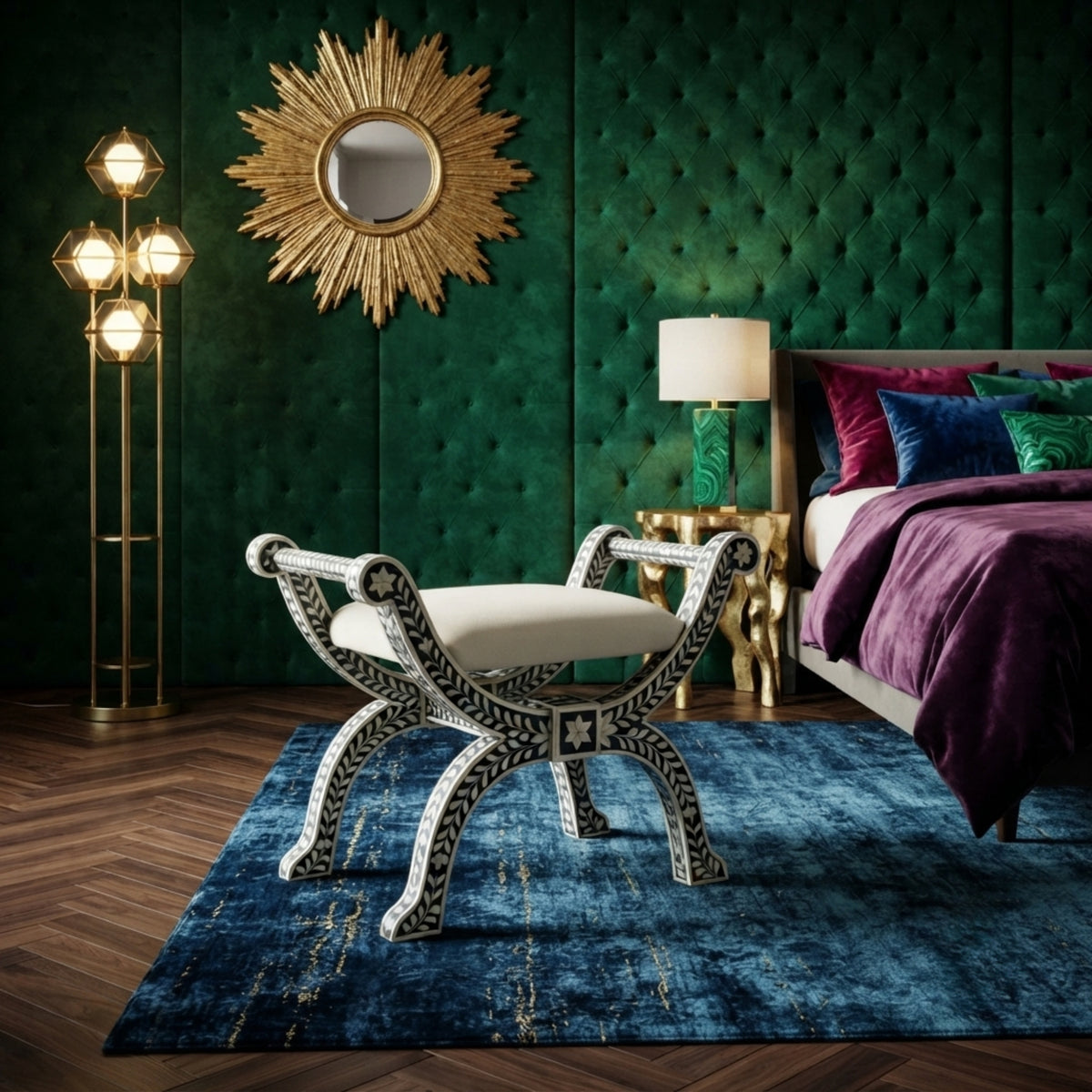 A styled bedroom scene featuring a decorative white bench with black geometric patterns and a cream cushion, placed on a blue rug in front of a bed with purple bedding and a green tufted wall.