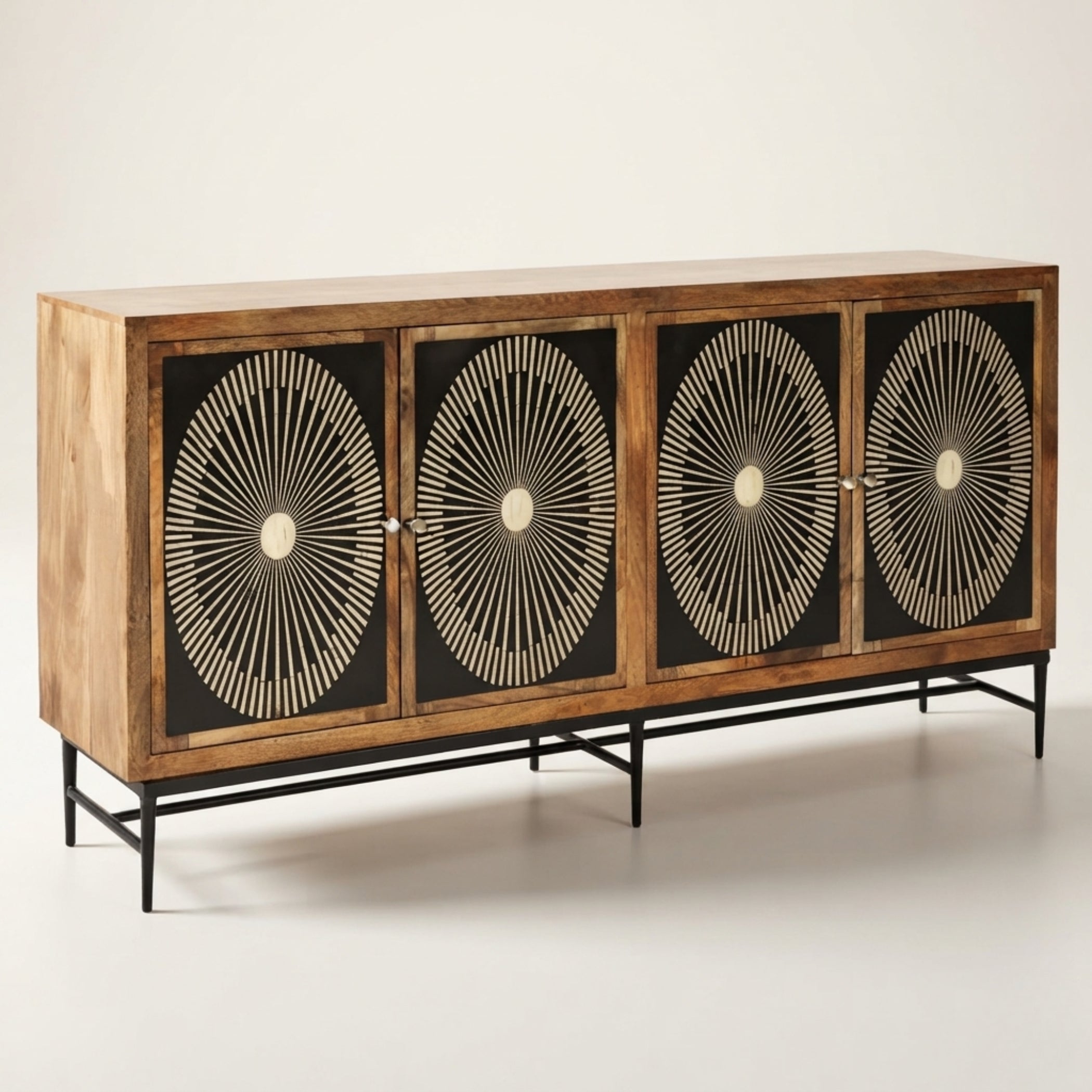 A mid-century modern wooden credenza with four doors featuring black backgrounds and intricate beige sunburst inlay patterns, supported by a black metal frame.