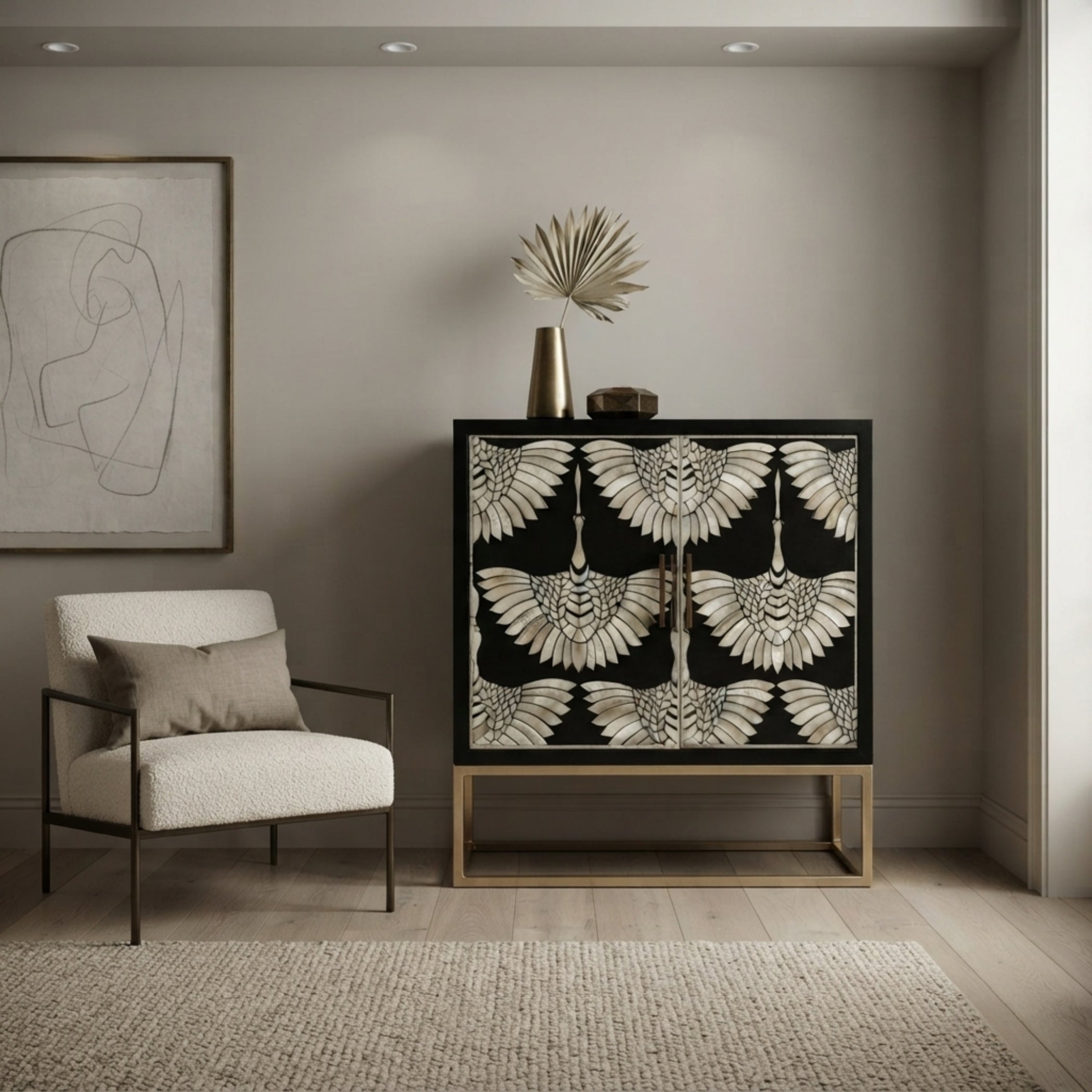 A modern sideboard cabinet with a black background and a detailed beige and white bird pattern on the doors, styled in a minimalist room next to a white armchair.