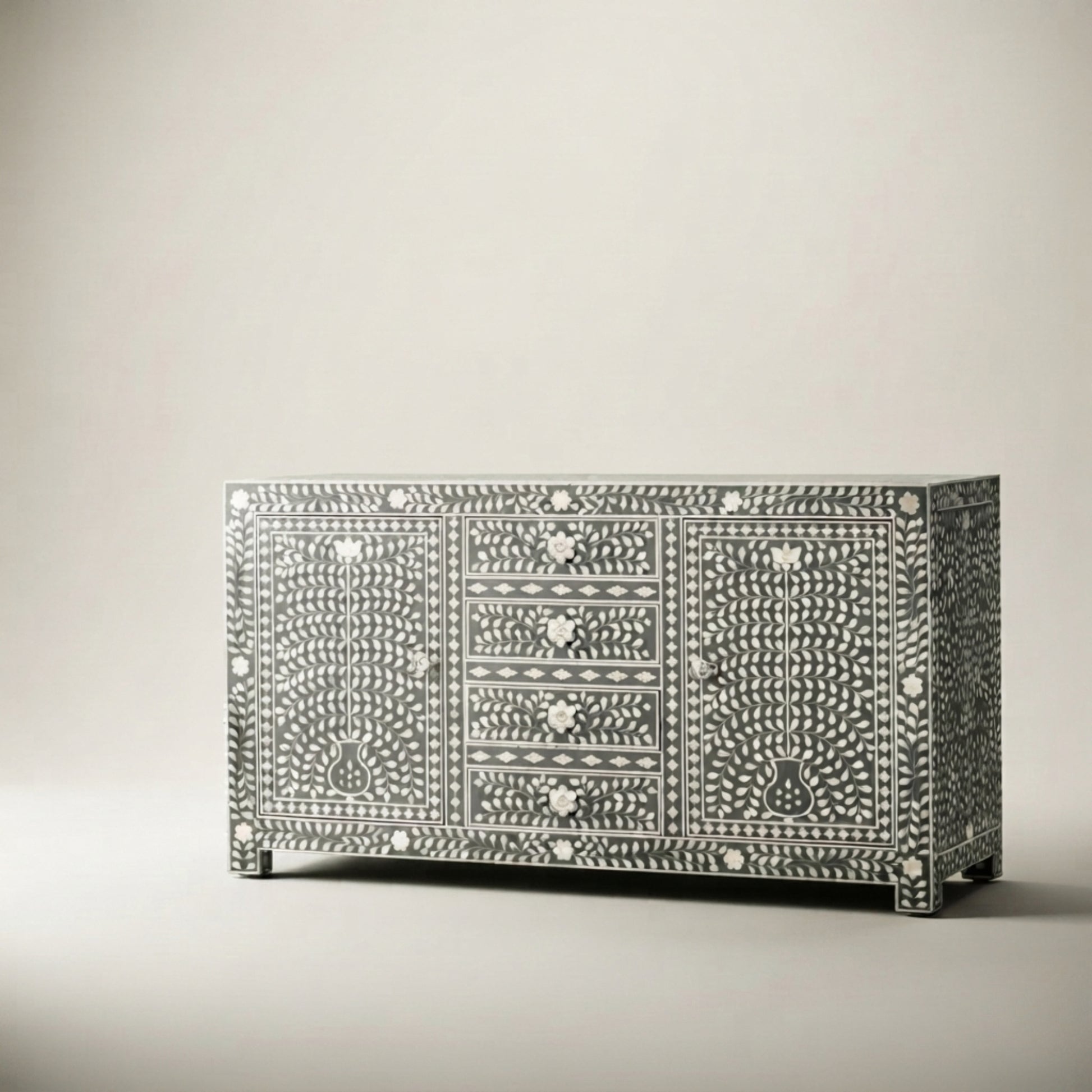 A bone-inlay sideboard cabinet with three drawers and two doors, featuring intricate black and white bone patterns, photographed on a neutral light gray background.
