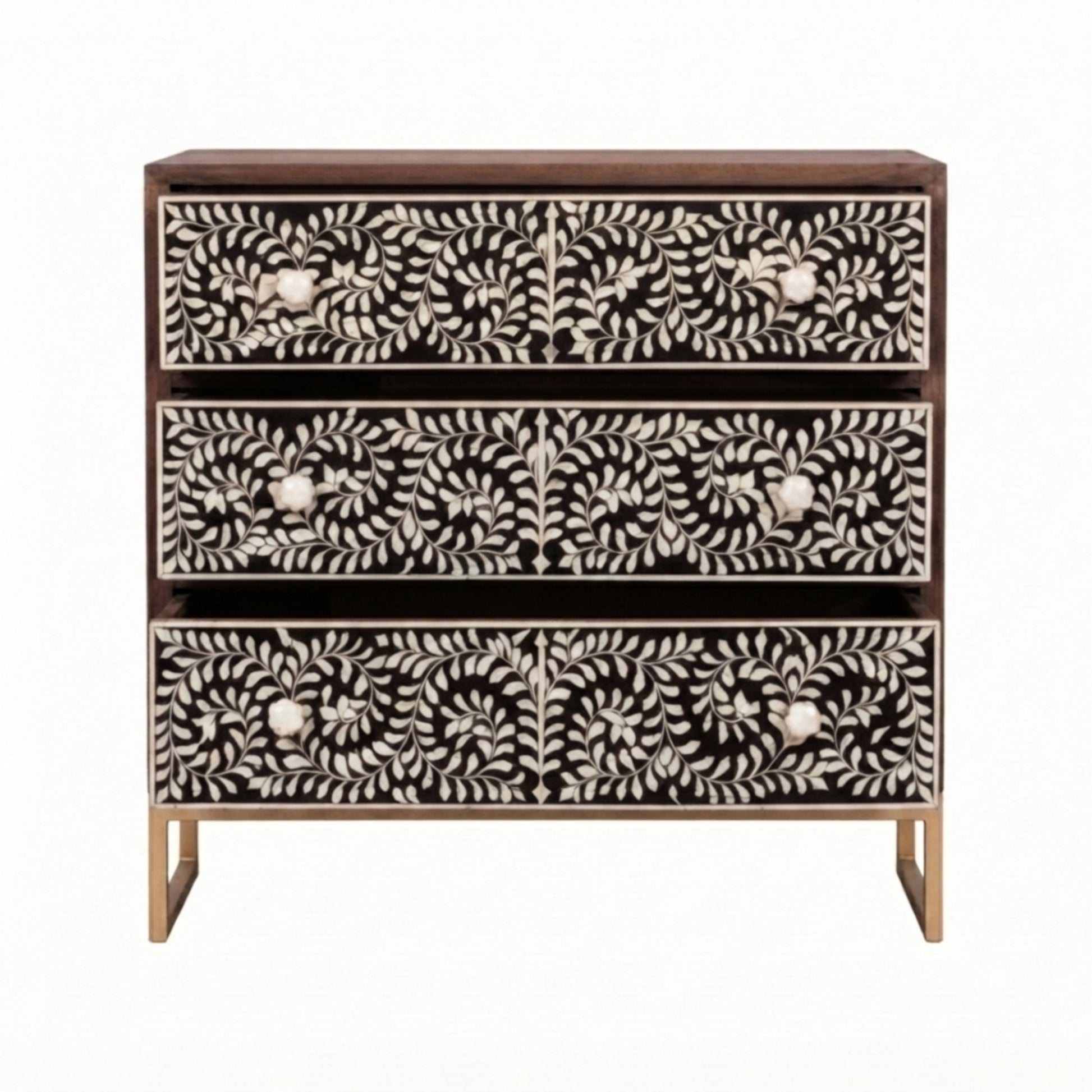 A three-drawer chest of drawers with a dark brown wood frame and intricate bone-inlay drawer fronts featuring a black and white floral and leaf pattern, supported by gold-toned legs.