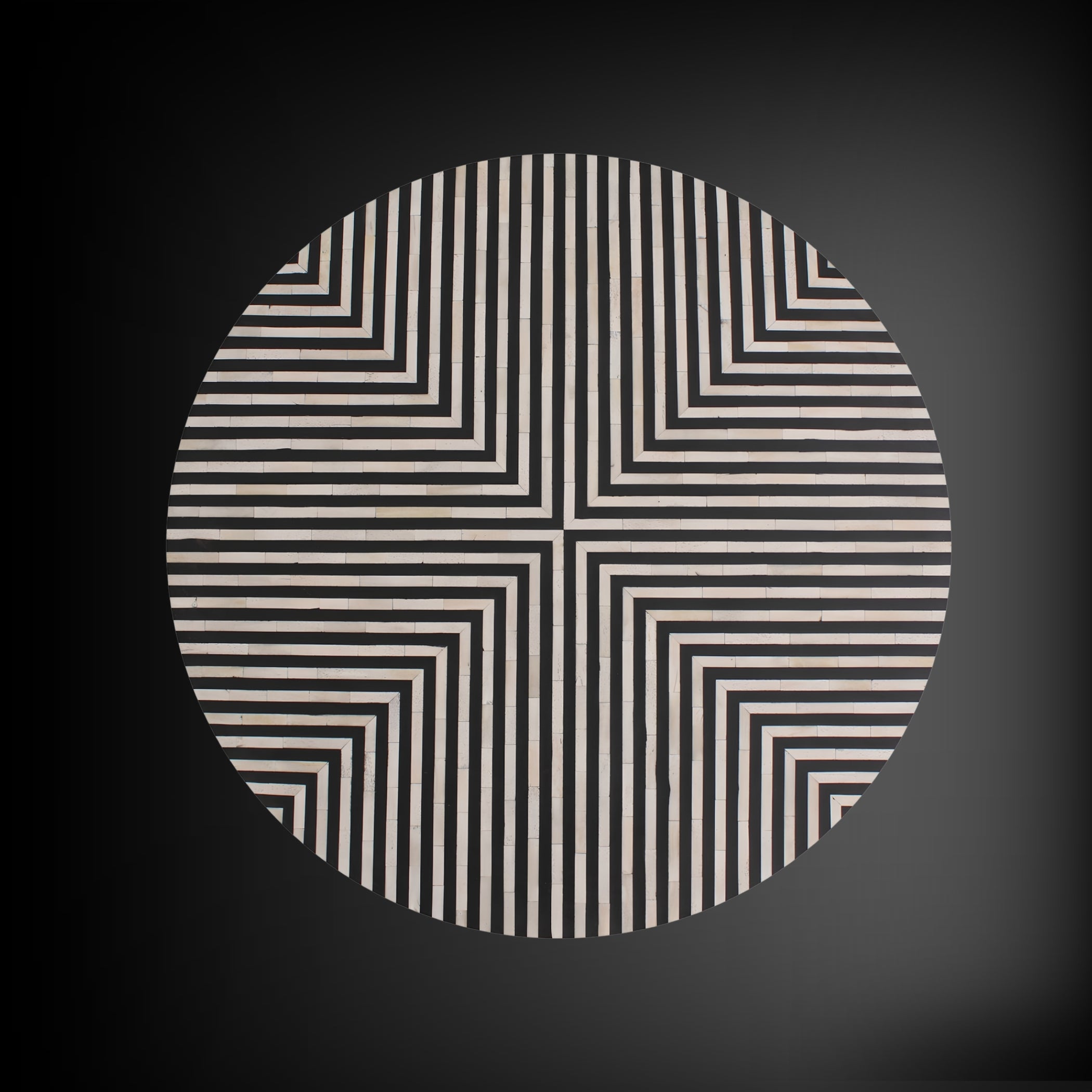 A circular area rug with a black and cream geometric optical illusion pattern, centered on a dark gray background.