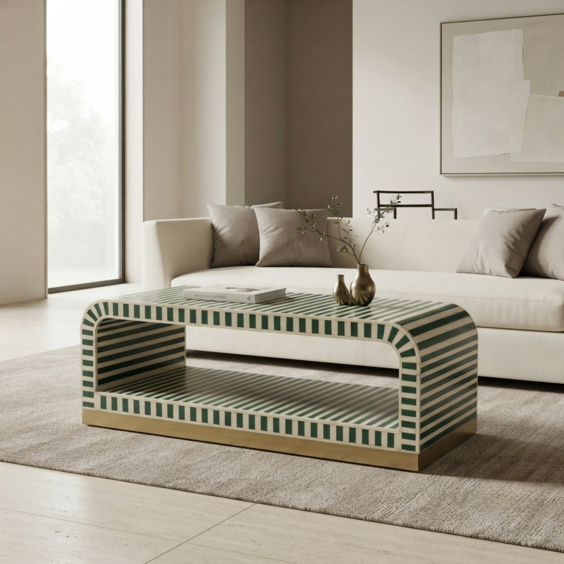 A modern rectangular coffee table with a green and white striped pattern and a gold-toned base, styled in a minimalist living room next to a white sofa.