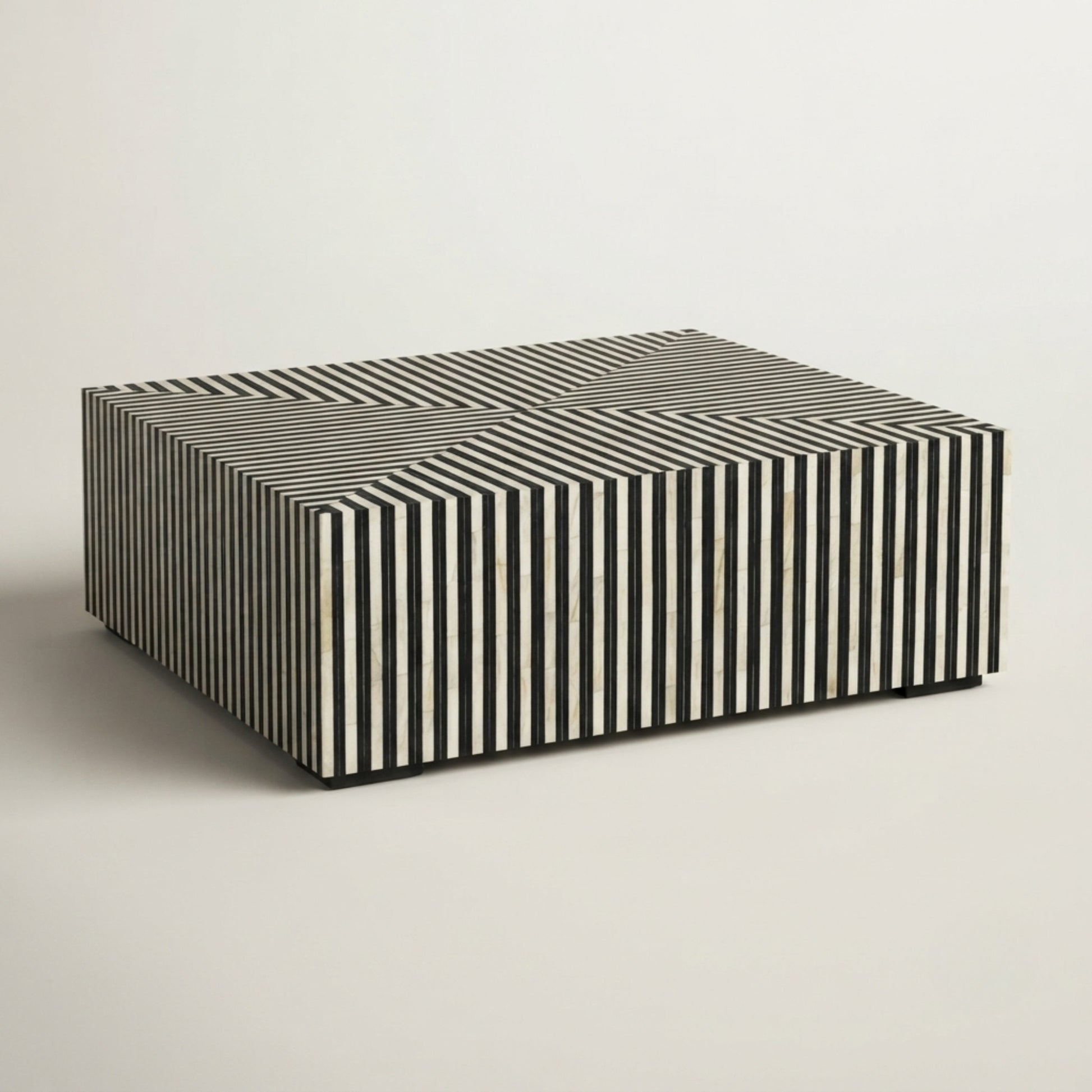 A rectangular coffee table with a black and white striped bone-in-wood exterior and a solid black top, photographed on a neutral light gray background.