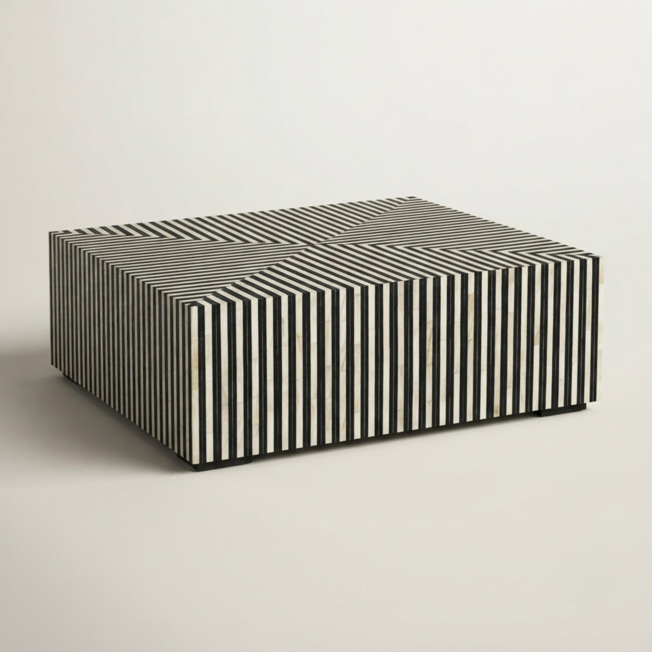 A rectangular coffee table with a black and white striped bone-in-wood exterior and a solid black top, photographed on a neutral light gray background.