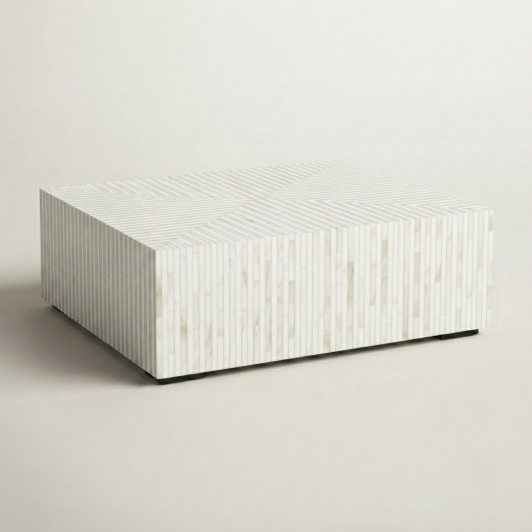 A rectangular coffee table with a white and beige striped shell or wood veneer pattern, shown on a neutral light beige background.