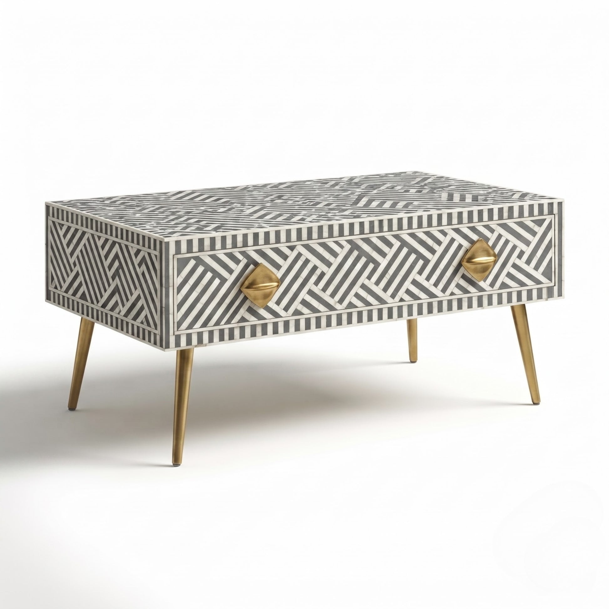 A rectangular bone-in-bone coffee table with a geometric black and off-white pattern, two gold geometric pulls, and tapered gold legs, shown on a white background.