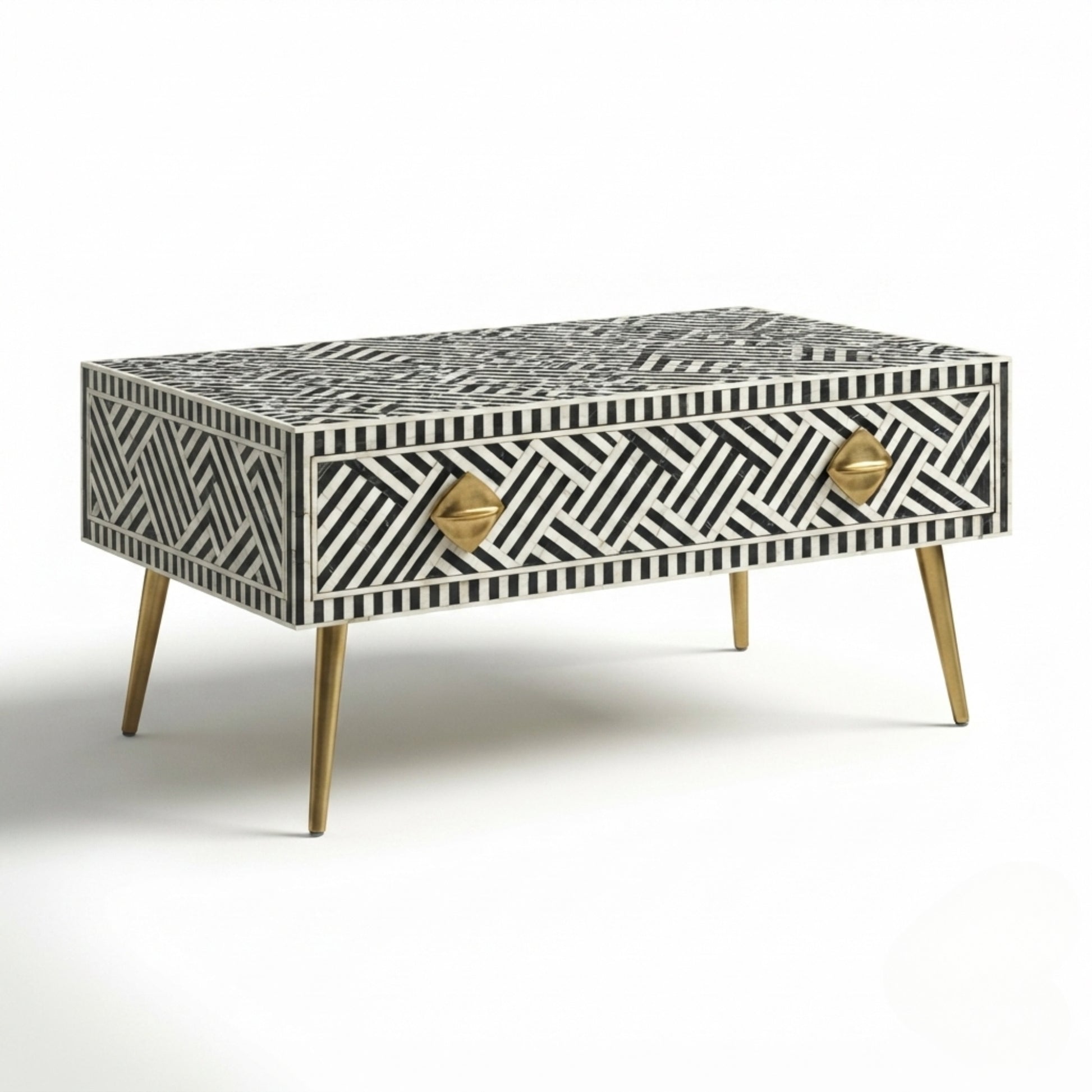 A rectangular bone-and-wood accent table with a black and white geometric inlay pattern, two gold-tone diamond-shaped drawer pulls, and tapered gold legs, shown on a white background.