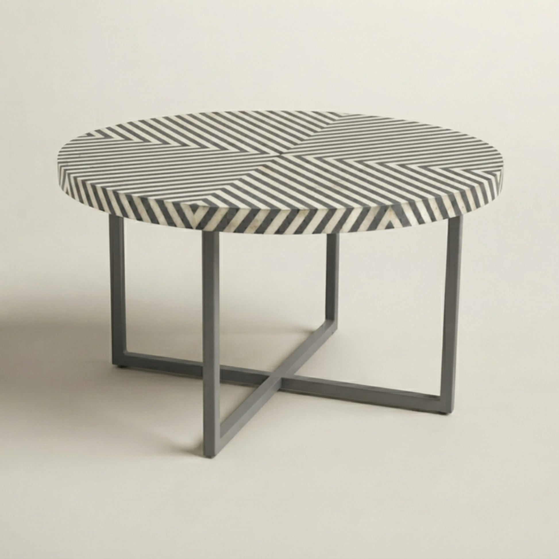 A round coffee table with a black and white striped patterned top and a gray metal frame base, shown against a neutral light gray background.